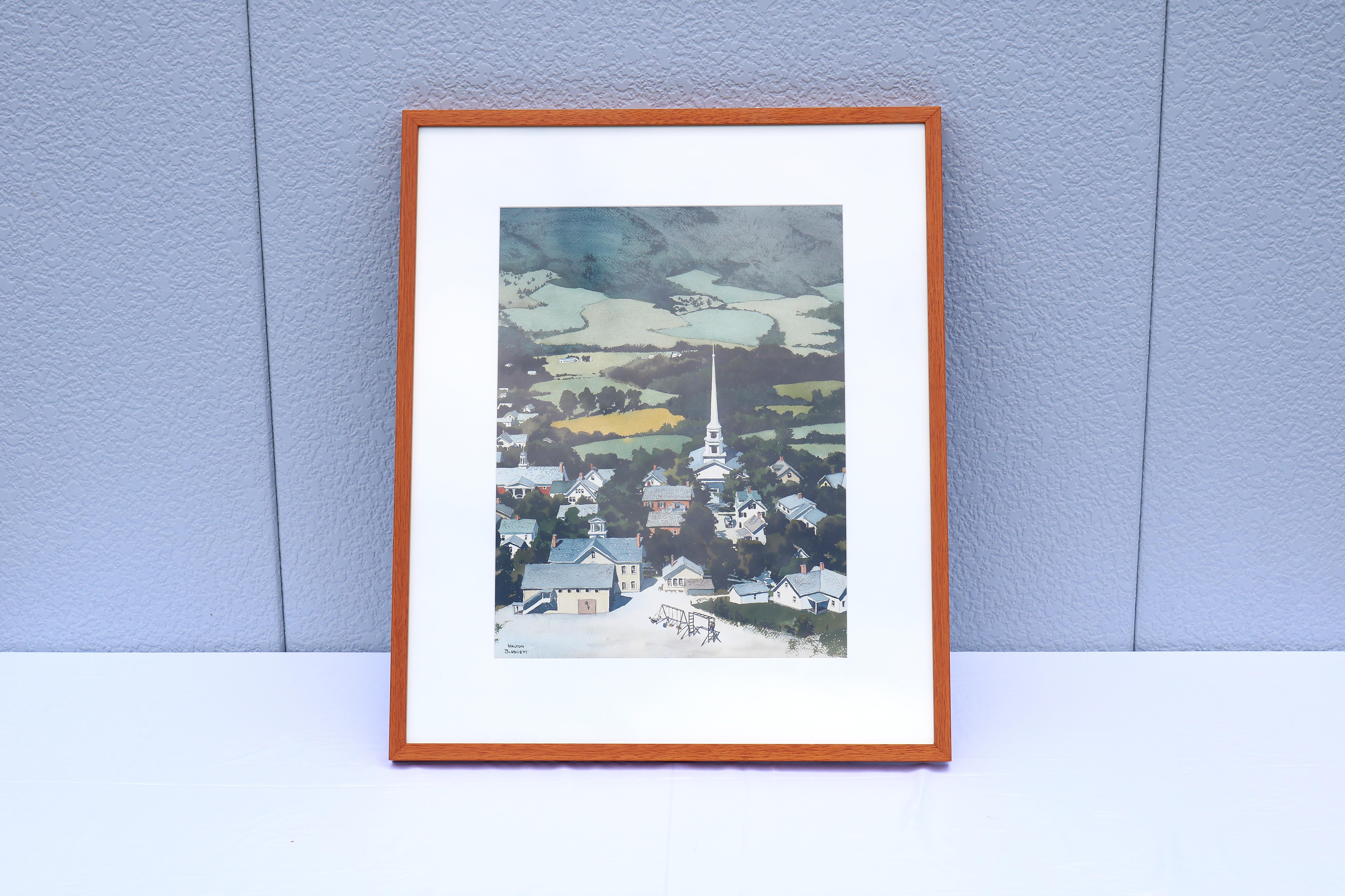 Favolosa stampa litografica di una città del New England incorniciata di Walton Blodgett del 1980, inchiostri su carta. La firma dell'artista è visibile nell'angolo in basso a sinistra.
L'opera d'arte raffigura una città del New England immersa in