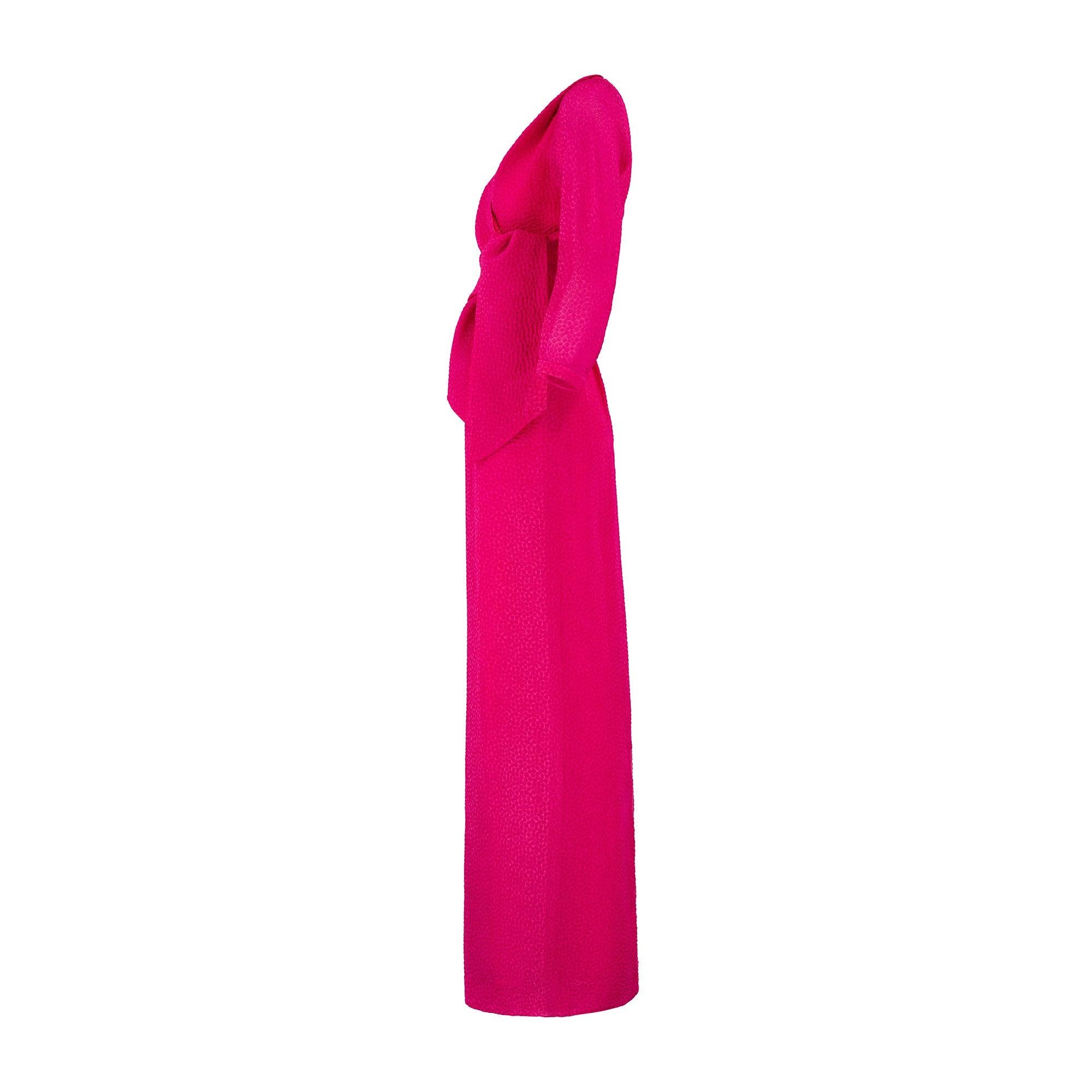 Wim Hemmink was a fashion and costume designer from the Netherlands who designed his playful occasion wear in London. This flamboyant and unusual 1980s one-shoulder dress with shrug is tailored from a vibrant fuchsia silk with a raised, polka-dot