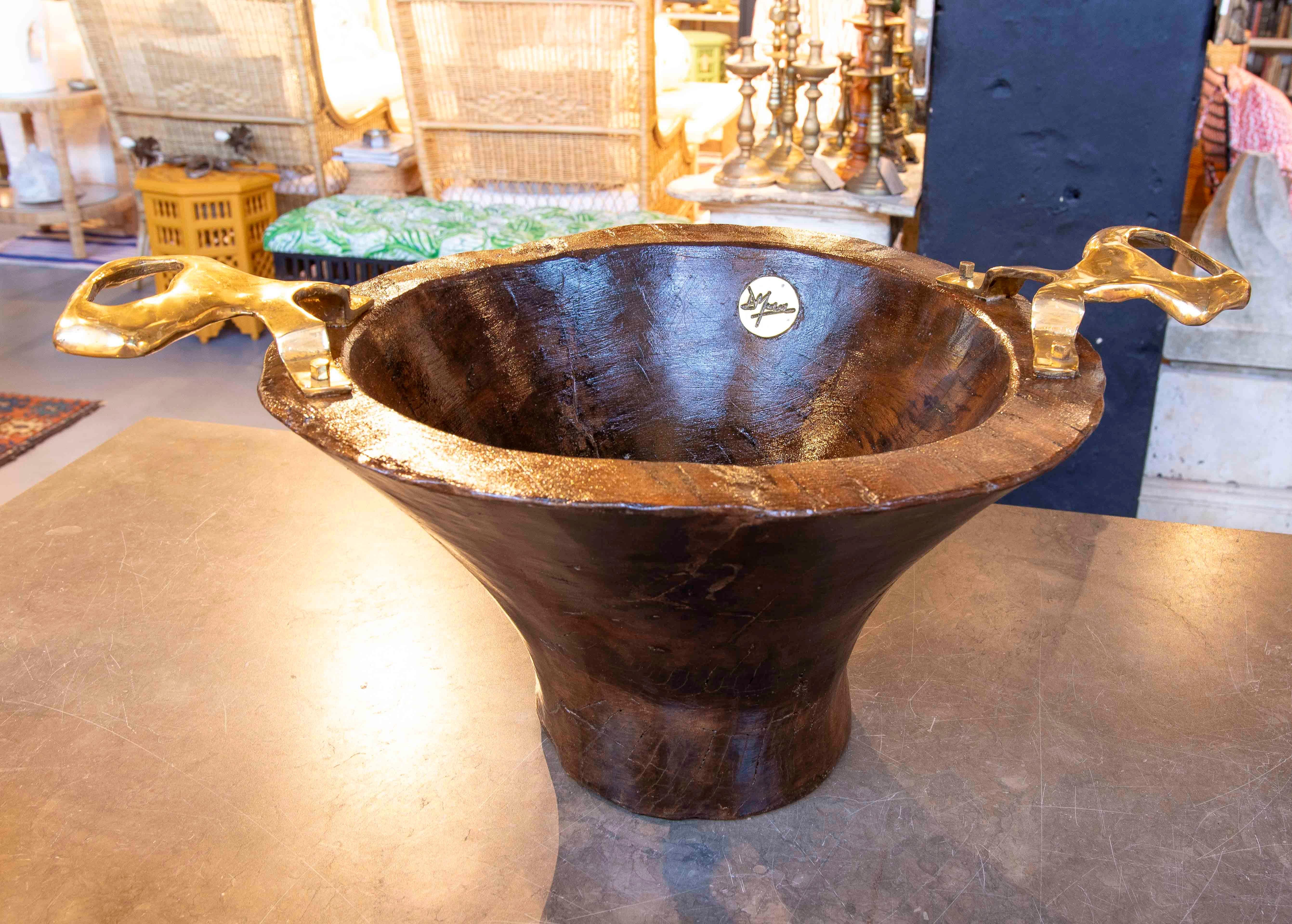 Ein einzigartiges skulpturales Stück aus Massivholz mit dunkler, glänzender Oberfläche, das sich durch seine organischen Formen und sein elegantes, zeitgenössisches Design auszeichnet. Die beiden markanten, frei geformten Bronzegriffe bilden einen