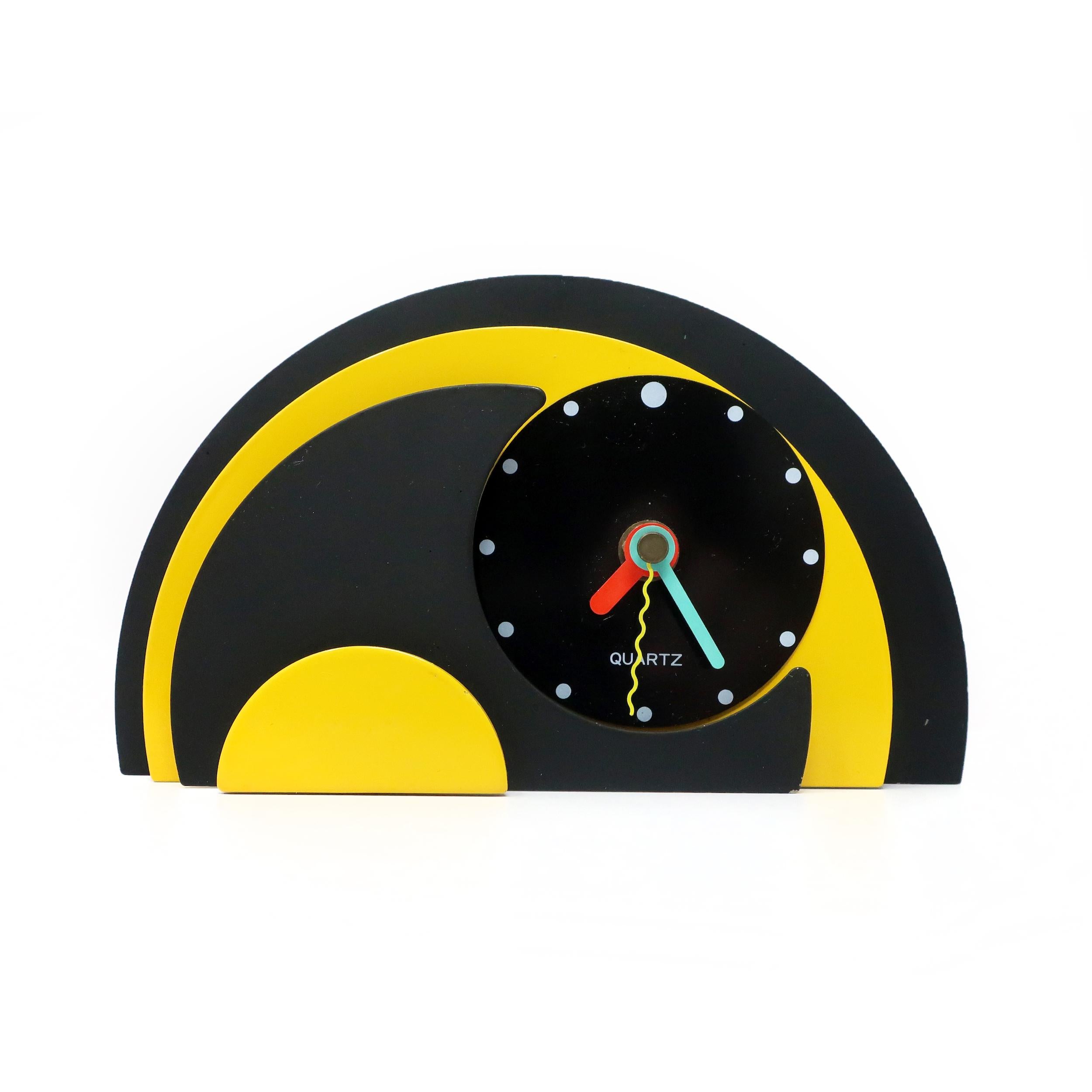 With a stunning combination of yellow, black, and enameled metal, black lucite accents, and primary-colored hands, this postmodern clock is designed with a stacked semi-circle design that gives it a rare and beautiful three-dimensionality. Bold