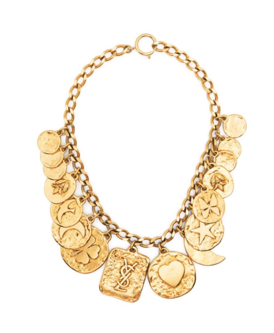  1980s YSL Yves Saint Laurent gold-plated charms necklace featuring a chunky chain, an adjustable length, a spring-ring fastening, pitted YSL at back charm.
 Maxi length: 16.54in. (42cm)
Charm YSL Width  1.5in. (4cm)
In excellent vintage condition 