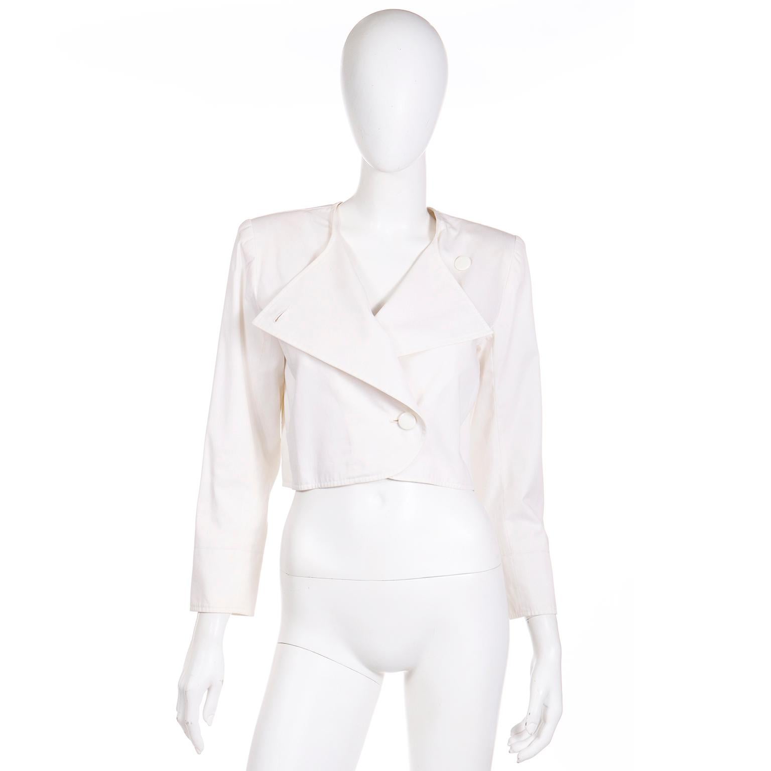 This vintage 1980's Yves Saint Laurent cropped jacket is in a luxe white cotton that is perfect for Summer!  This jacket has shoulder pads for structure, and a perfectly boxy cropped fit. You can choose to wear it closes with one button, to reveal