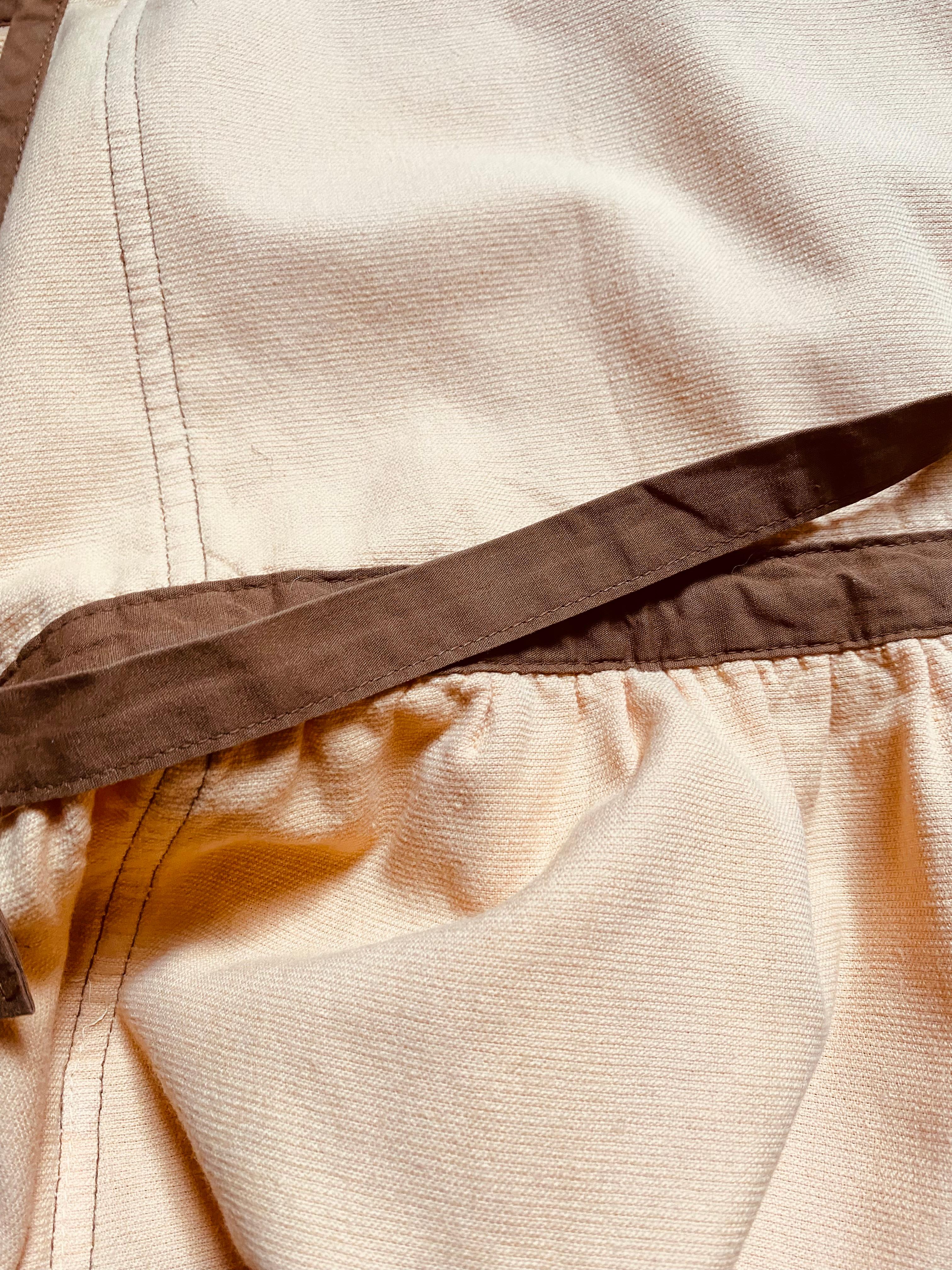 1980s Yves Saint Laurent  vintage apron, soft tan cotton with rich brown trim, it features the iconic embroidered YSL logo at the chest, adjustable neck and waist ties, and two roomy front pockets 


Color: Tan with brown trim
Material: Cotton