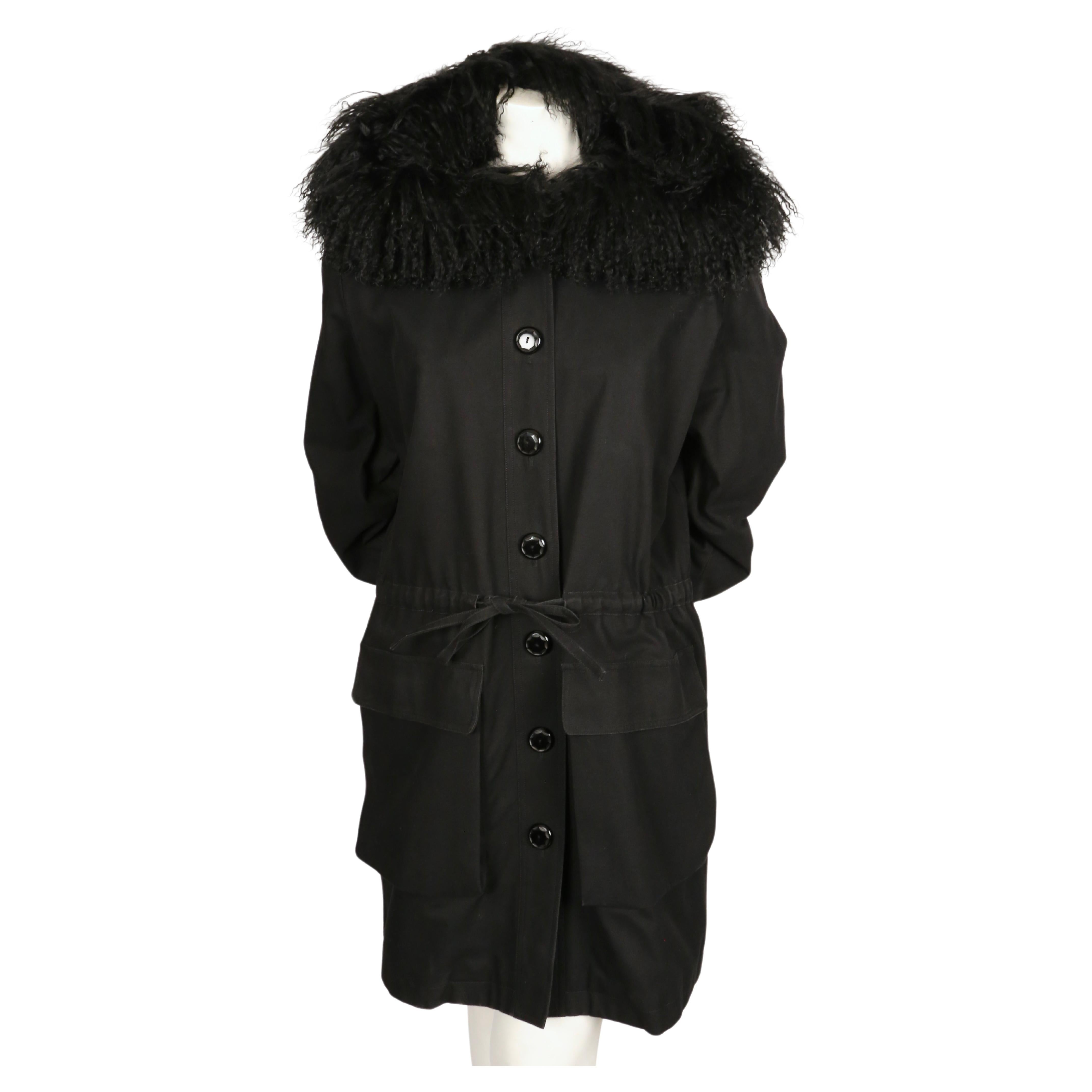 Very rare black cotton coat with oversized curly lamb fur hood, 3-D pockets, drawstring waist and quilted lining designed by Yves Saint Laurent dating to the 1980's. No size is indicated however this best fist a FR 38 to 42. Approximate