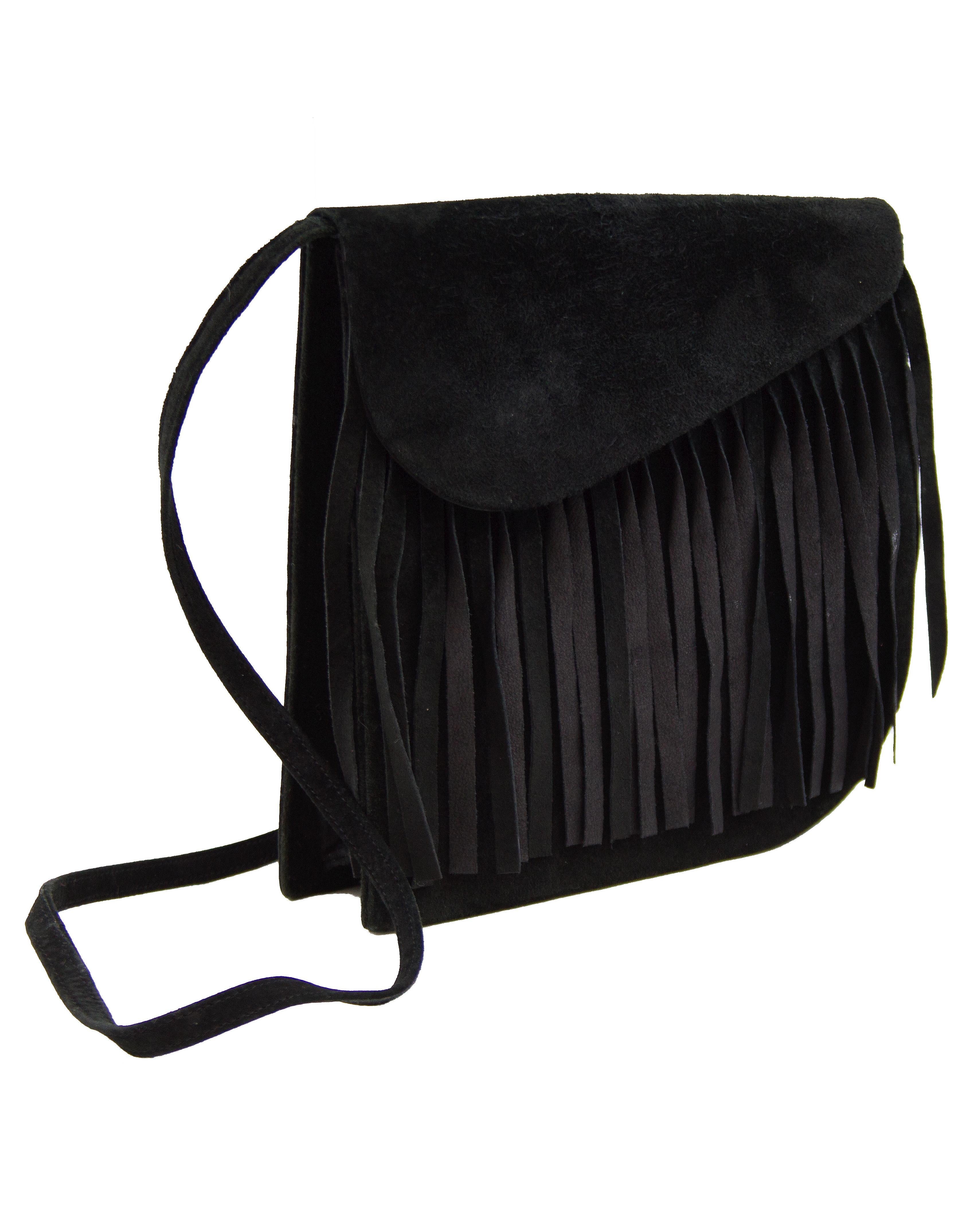 The ultimate 1980's Yves Saint Laurent accessory. Black suede bag with long strap that can be worn cross body. Fringe detail across front flap, giving that iconic elevated YSL hippy vibe. Purse flap closes with double gold magnetic snaps. Good