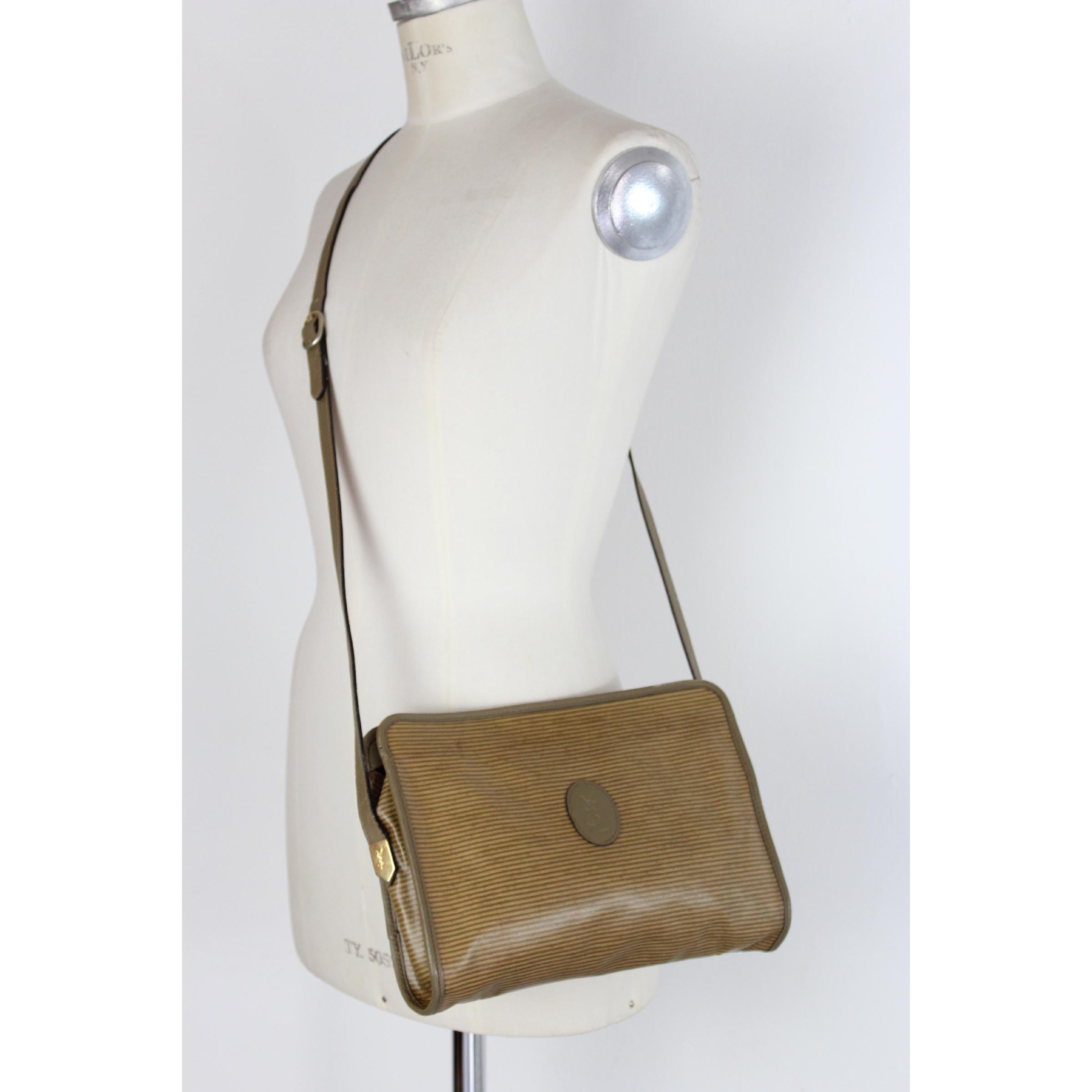 Vintage Yves Saint Laurent shoulder bag, beige in canvas and leather. Gold-colored details. Zip closure, internal dividers. 80s. Made in France. Good vintage condition, some small spots.

Width: 28 cm
Height: 20 cm
Depth: 6 cm