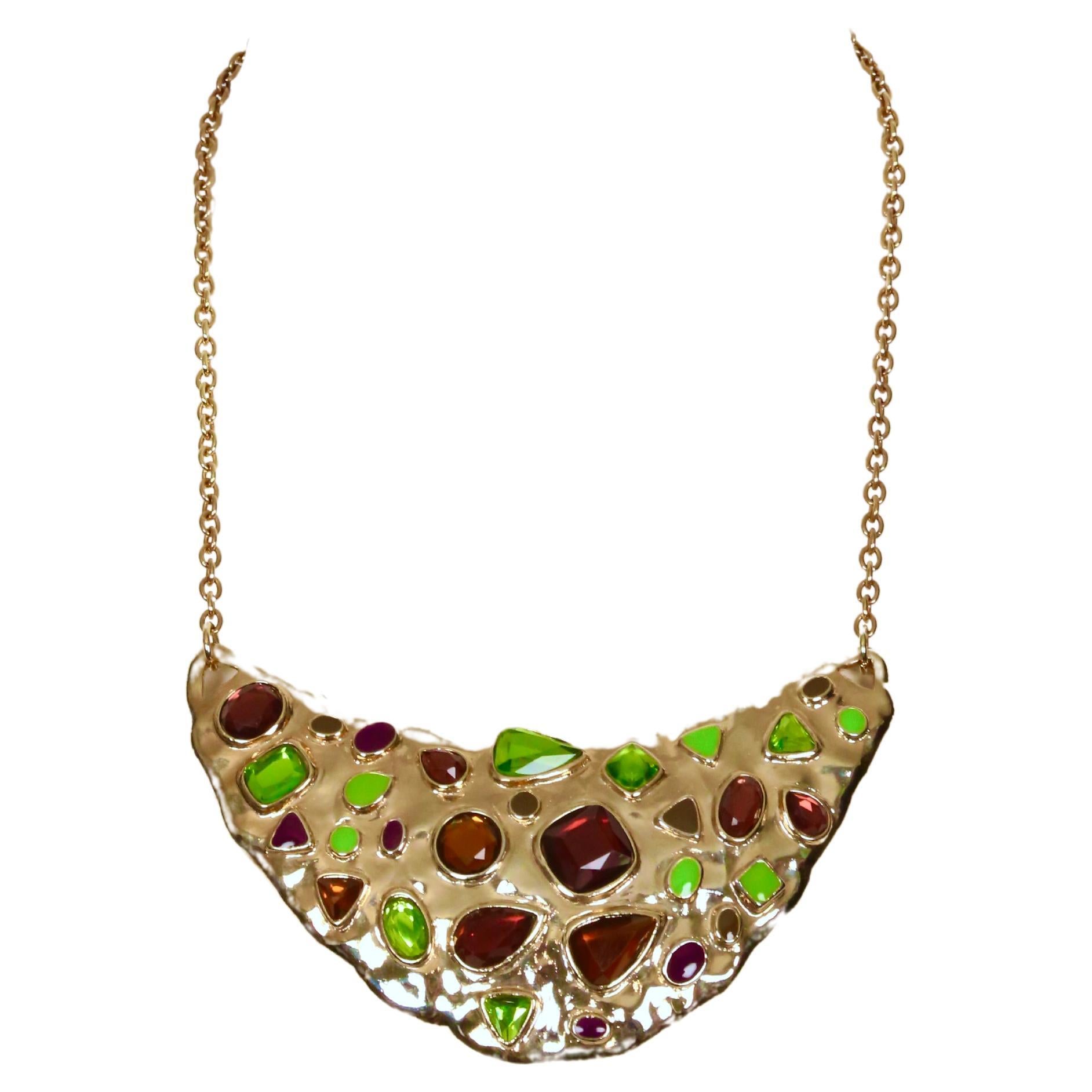Strepitosa collana a pettorina in cristallo sfaccettato con ametista, peridoto e topazio e accenti di smalto, disegnata da Yves Saint Laurent e risalente agli anni Novanta. Chiusura a molla regolabile. Misura circa 16-19