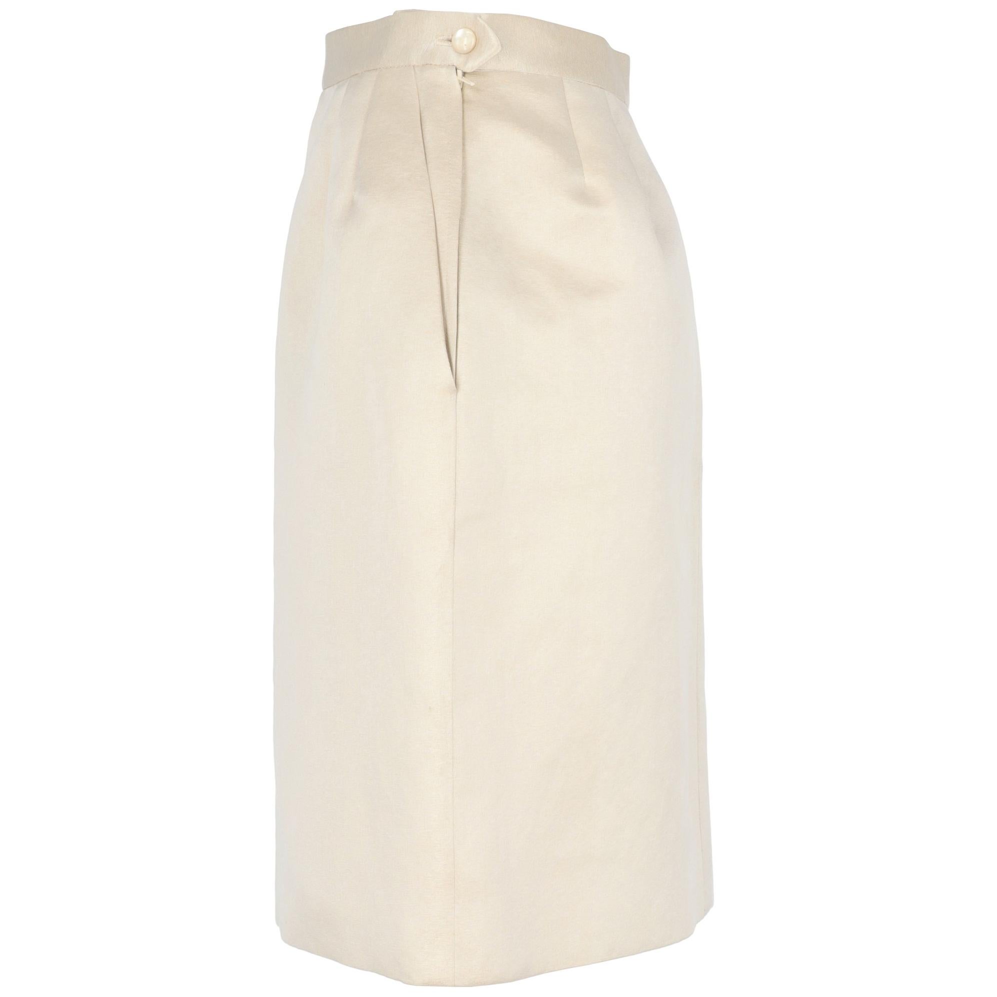 Yves Saint Laurent ivory silk knee-length skirt with golden weft thread. Amphora model and double waist pinces. Side closure with mother-of-pearl button and zip, side welt pockets and double pinces on the back. Acetate lining.

The item shows small