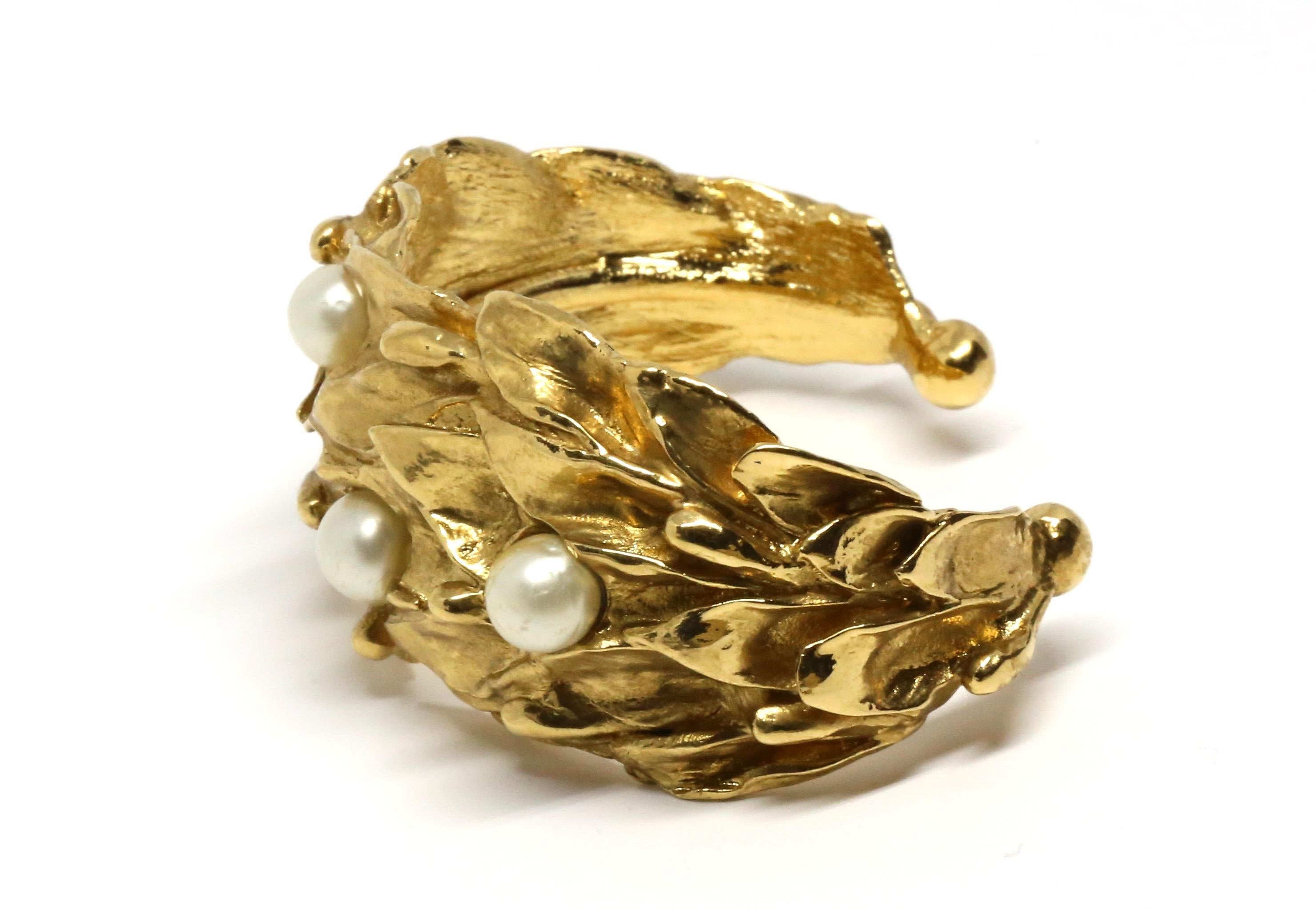Organically shaped gilt cuff with faux pearls from Yves Saint Laurent dating to the 1980's. Fits a small/medium wrist.  Interior measurements are very difficult to take, however the cuff fits loosely on a 6