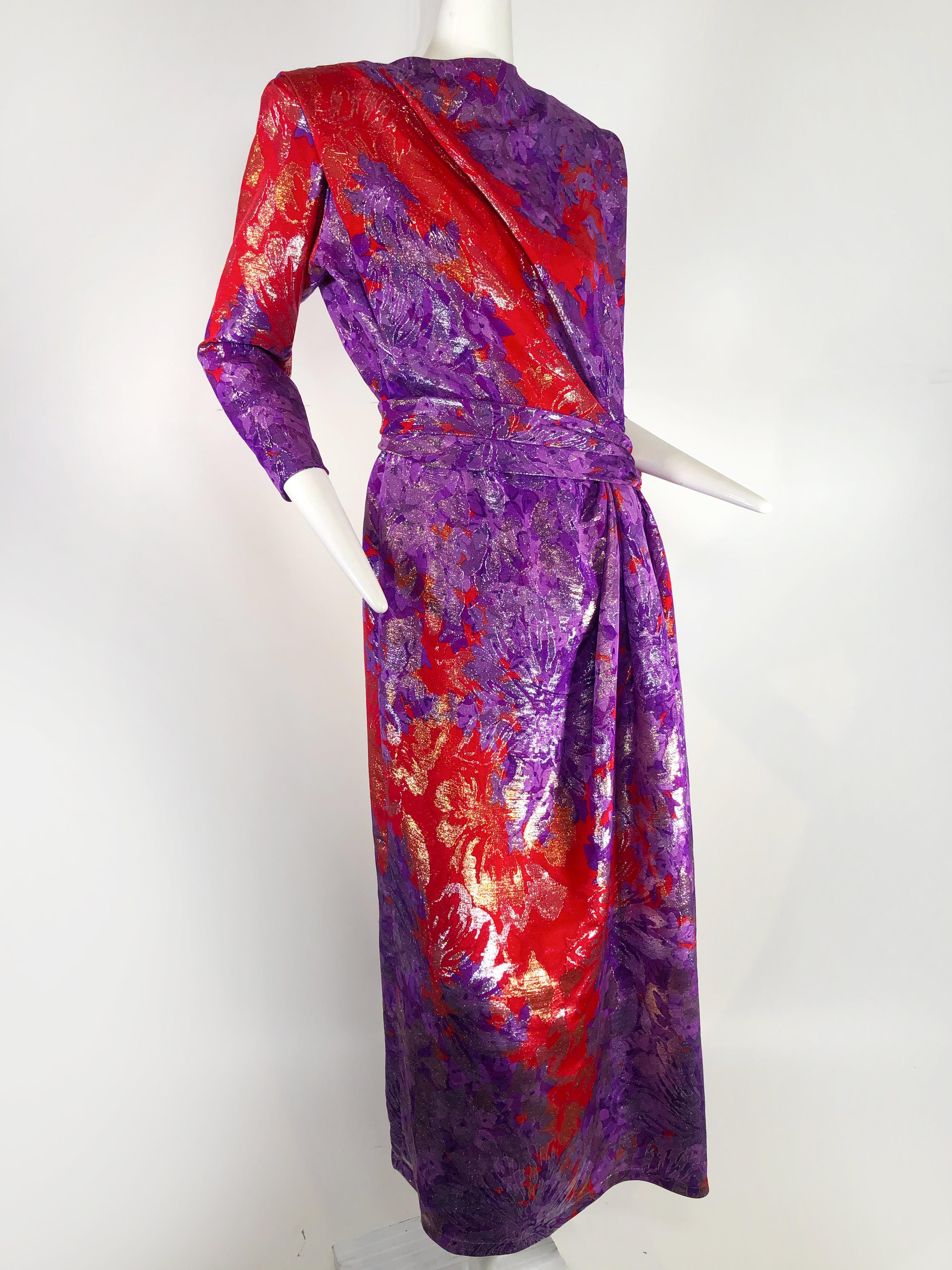 robe Yves Saint Laurent des années 1980 en brocart fleuri violet, rouge et or avec ceinture.  Dos échancré, fente latérale. Entièrement doublé.
