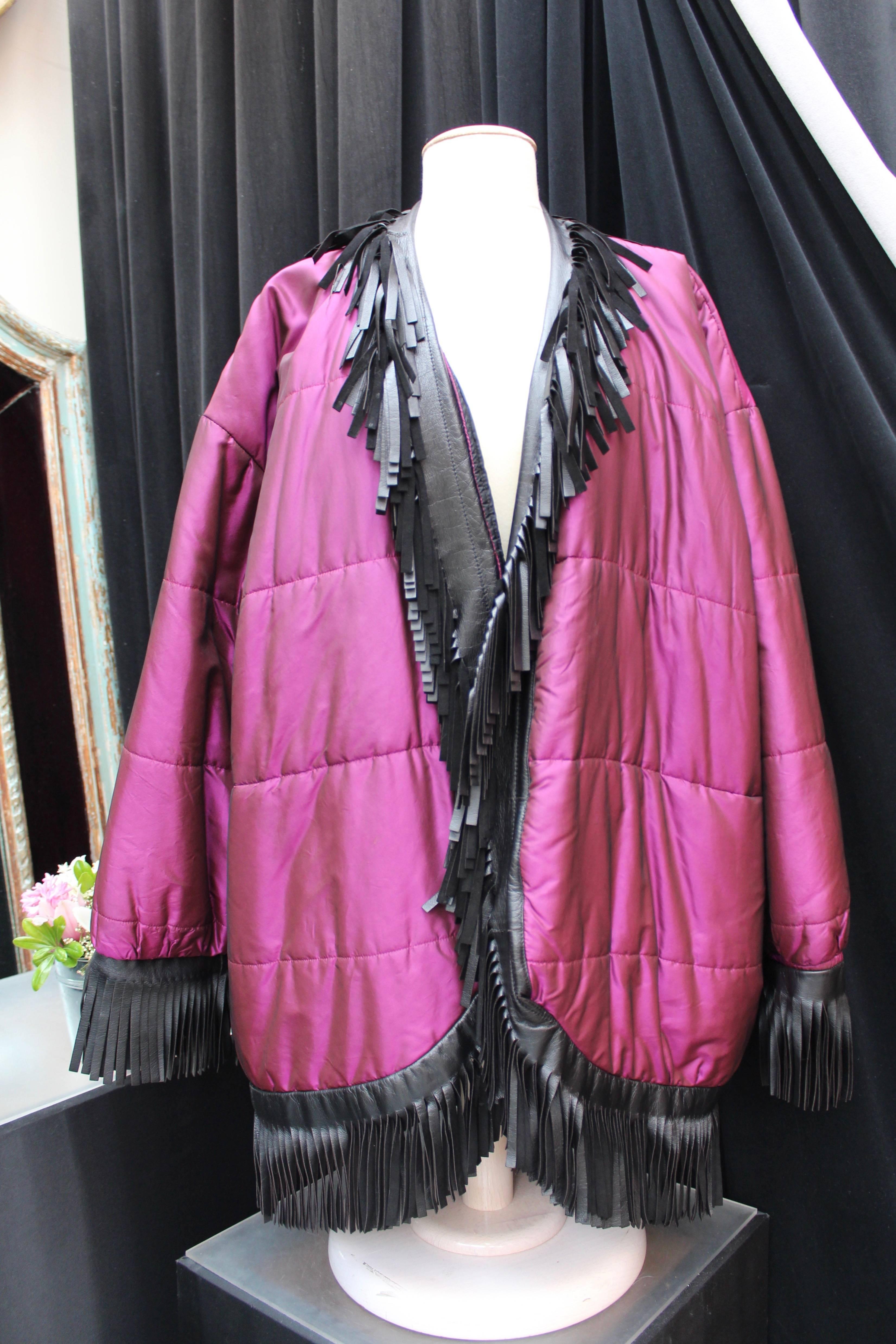 YVES SAINT LAURENT RIVE GAUCHE (Made in France) Long jacket composed of waterproof glossy metallic purple fabric. It is trimmed with black leather fringes. Black glossy lining.

Circa 1985-1990.

Indicated size 44 but can also fit a 46 (US 12/14