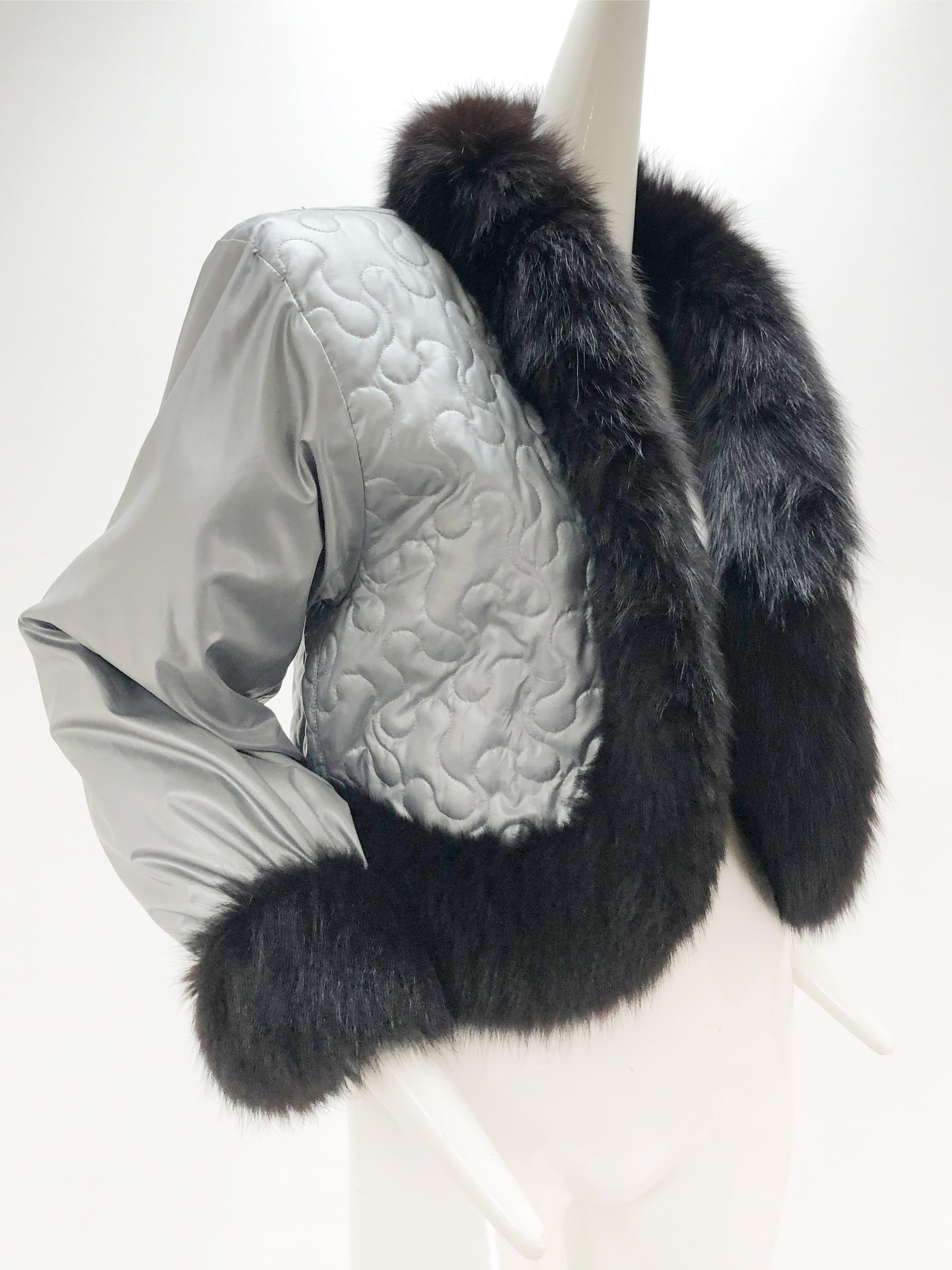 A wonderful 1980s Yves Saint Laurent quilted silver nylon cropped coat with black fox fur trim everywhere! This piece follows his Russian themed collections and is quilted in a passimenterie style and cropped short. No front closure. Fits
