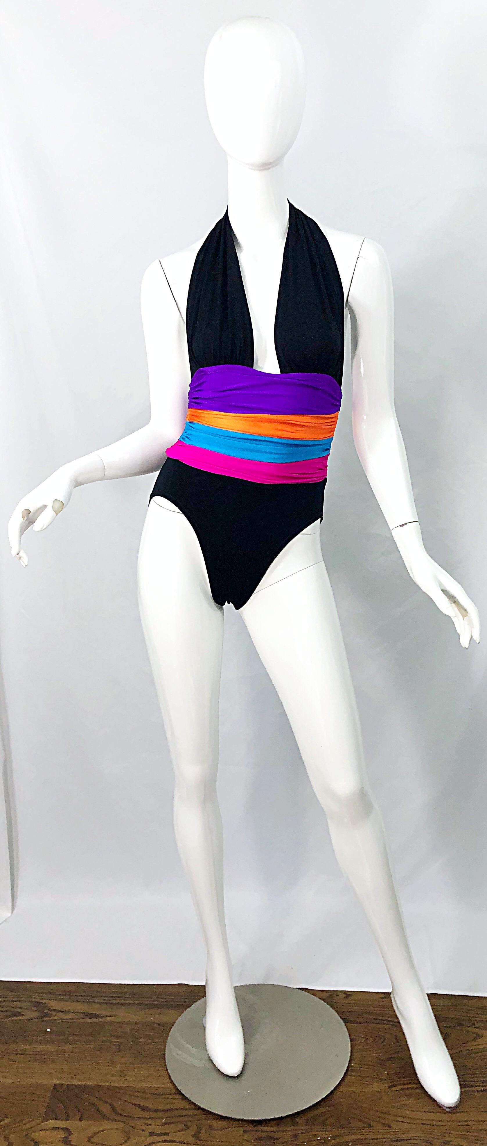 Sexy vintage early 80s YVES SAINT LAURENT YSL for Saks 5th Avenue plunging halter one piece bodysuit or swimsuit ! Swimsuit is a black lycra with color block stripes of purple, neon orange, turquoise blue and hot pink below the bust. Clasp at back