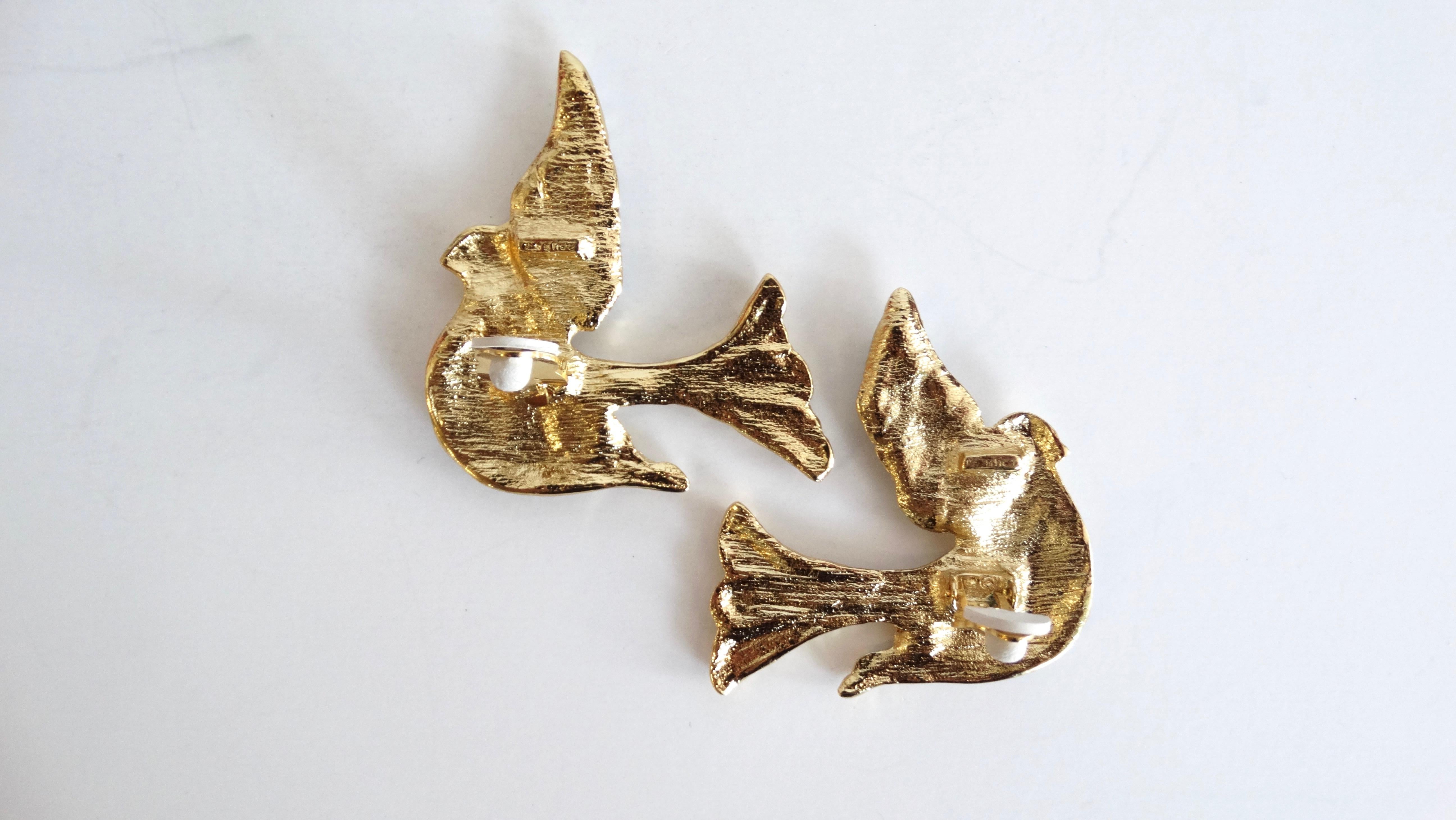 Add some vintage to your jewelry box with our bedazzled bird earrings from 1980s Yves Saint Laurent! Gold flying sparrows embellished with stripes of blue rhinestone crystals! Clip on style backs, each signed YSL. 