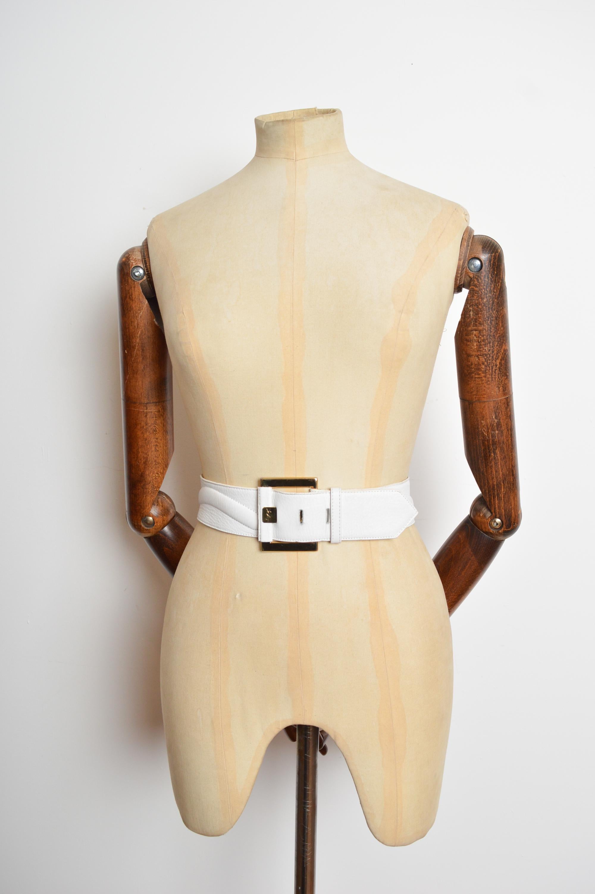 Una favolosa cintura di Yves Saint Laurent del 1980. Realizzata in pelle bianca con dettagli applicati e fibbia in metallo dorato. 
PRODOTTO IN FRANCIA.
Le misure sono indicate in pollici ('')
Misura di vita consigliata: 31'' / 32'' / 33''