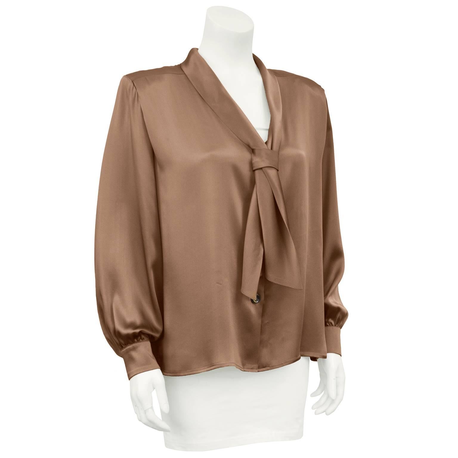 1980s Yves Saint Laurent champange silk bishop sleeve blouse. V neck with a tie at neckline. Right side of tie is tacked down and the left side just slips into the knot. Large shoulder pads can be removed easily. Excellent vintage condition. Marked