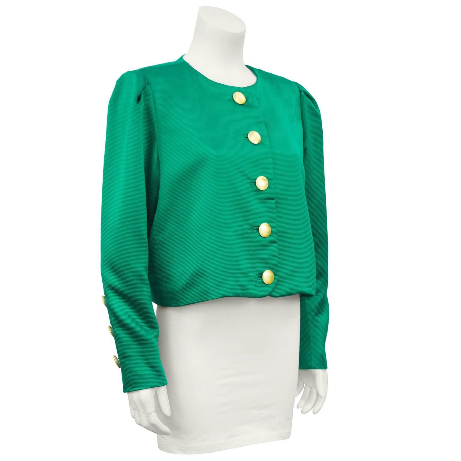 Vibrant 1980s Yves Saint Laurent ribbed emerald green silk and acetate cropped jacket. The emerald pops beautifully against the large round gold tone buttons. Monochromatic emerald green lining. Excellent vintage condition. Marked size FR 44 - fits