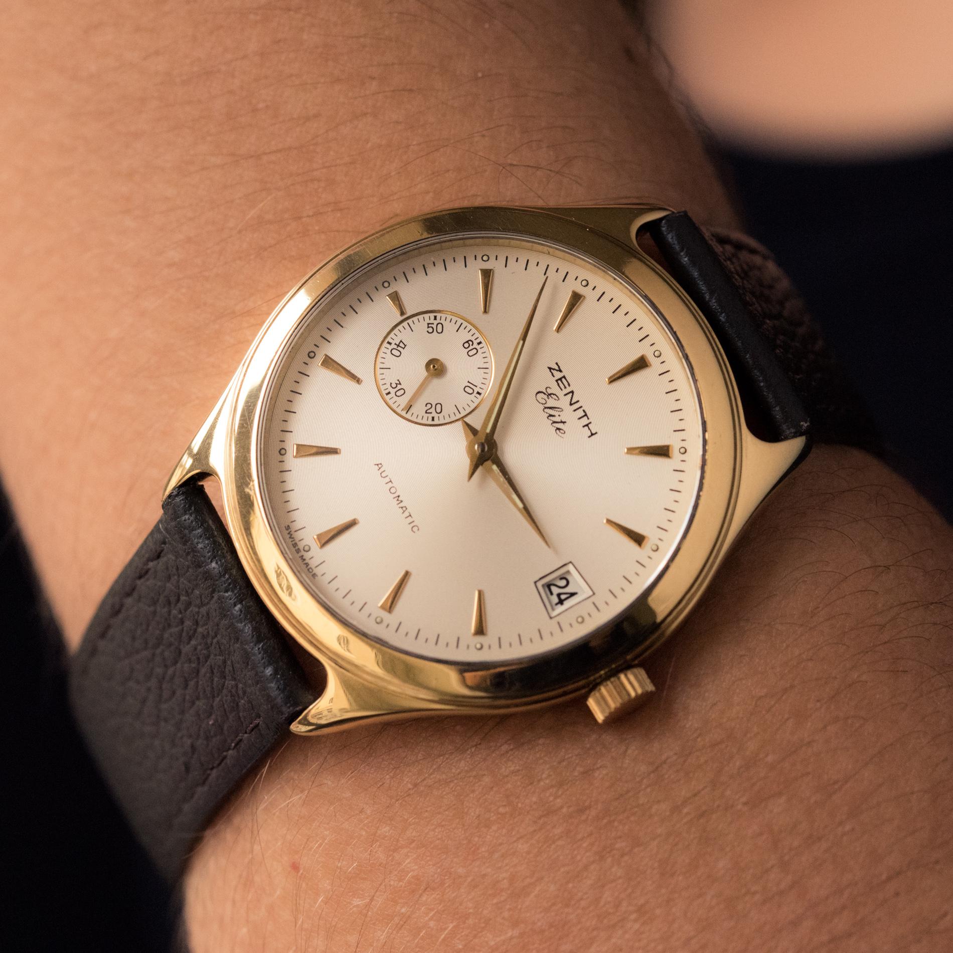 Bracelet watch for men in 18 karat yellow gold.
The dial is round, the background is creamy white stick figures, date at 3 o'clock, seconds dial at 9 o'clock.
Automatic movement with manual winding.
Zenith Elite Automatic brand.
Skeleton back.
The
