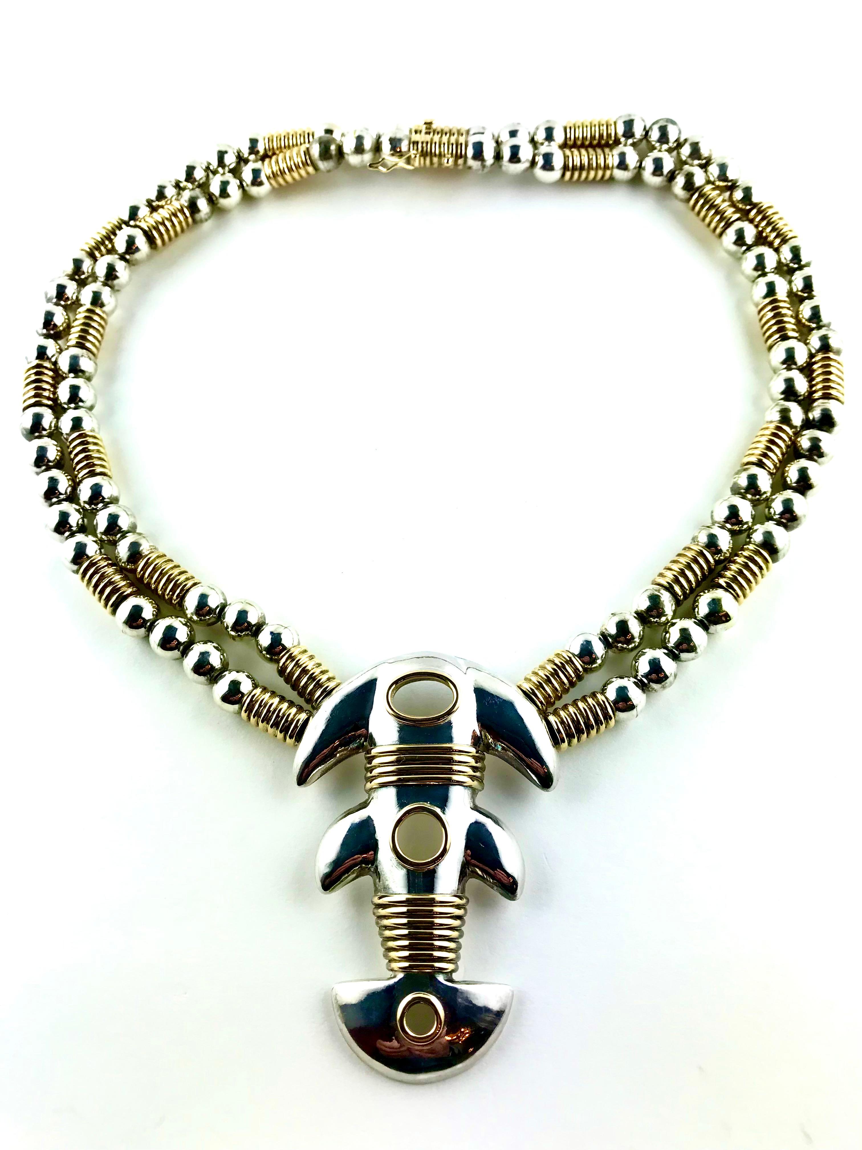 Sculptural, bold demi-parure crafted  in Yellow Gold and Silver by Greek design house Zolotas in the 1980s.  The chunky necklace features a double-stranded design with Silver spheres alterned by ribbed cylinders in 18k Gold and an eye-catching
