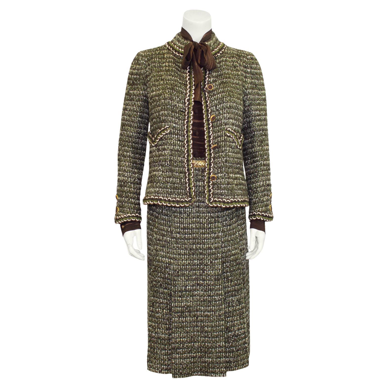 Show stopping 1981 green and brown Chanel Couture six piece ensemble including a jacket, blouse, skirt, scarf, brooch and belt. Mandarin collar jacket with green, brown and cream passimenterie trim. Carved gold buttons with brown centres. Patch