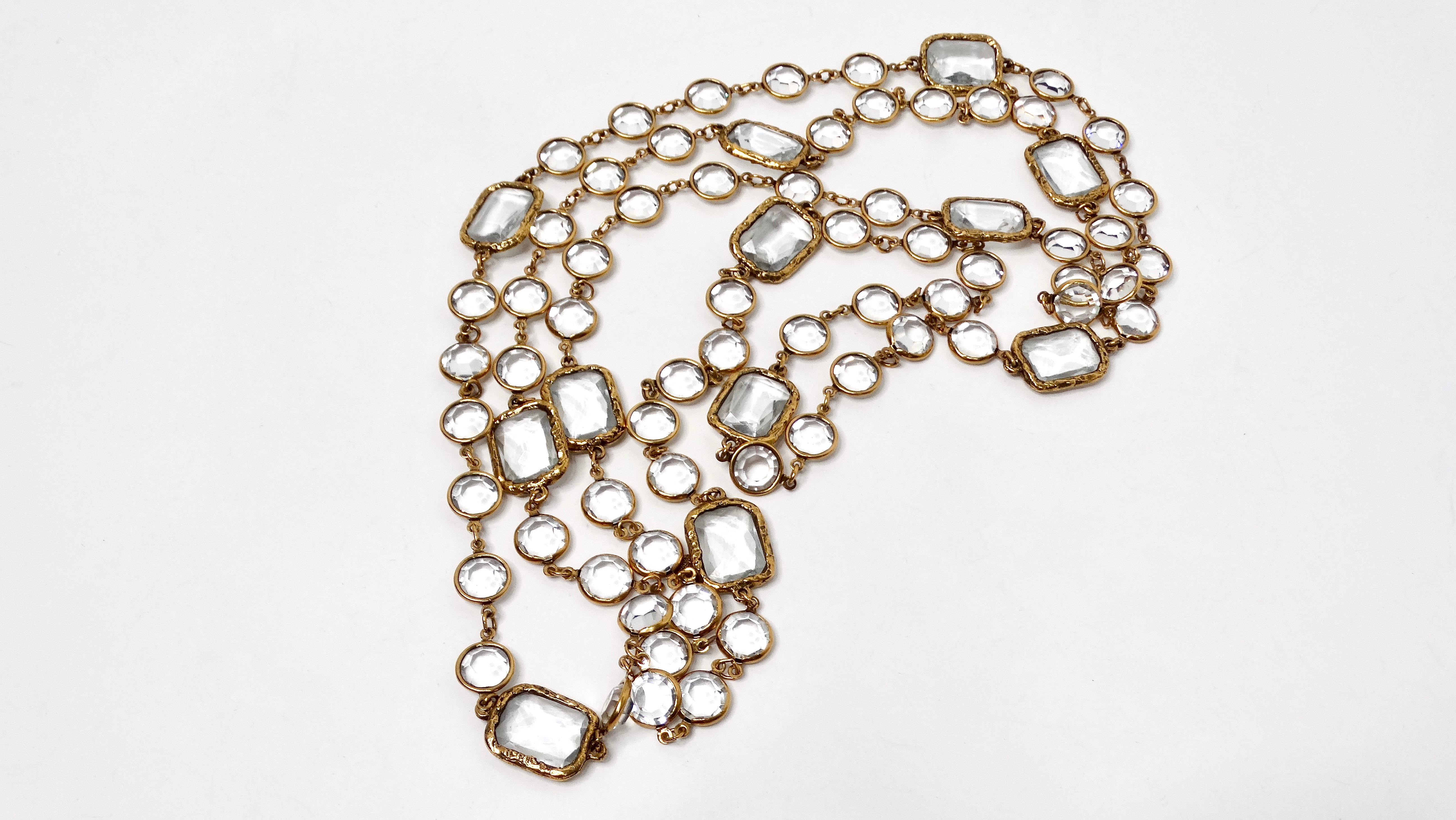 La collana lunga Chanel 1981 con cristalli trasparenti e catena placcata oro è un pezzo straordinario che incarna l'eleganza senza tempo e il design innovativo per cui Chanel è famosa. Caratterizzato da una serie di audaci cristalli trasparenti