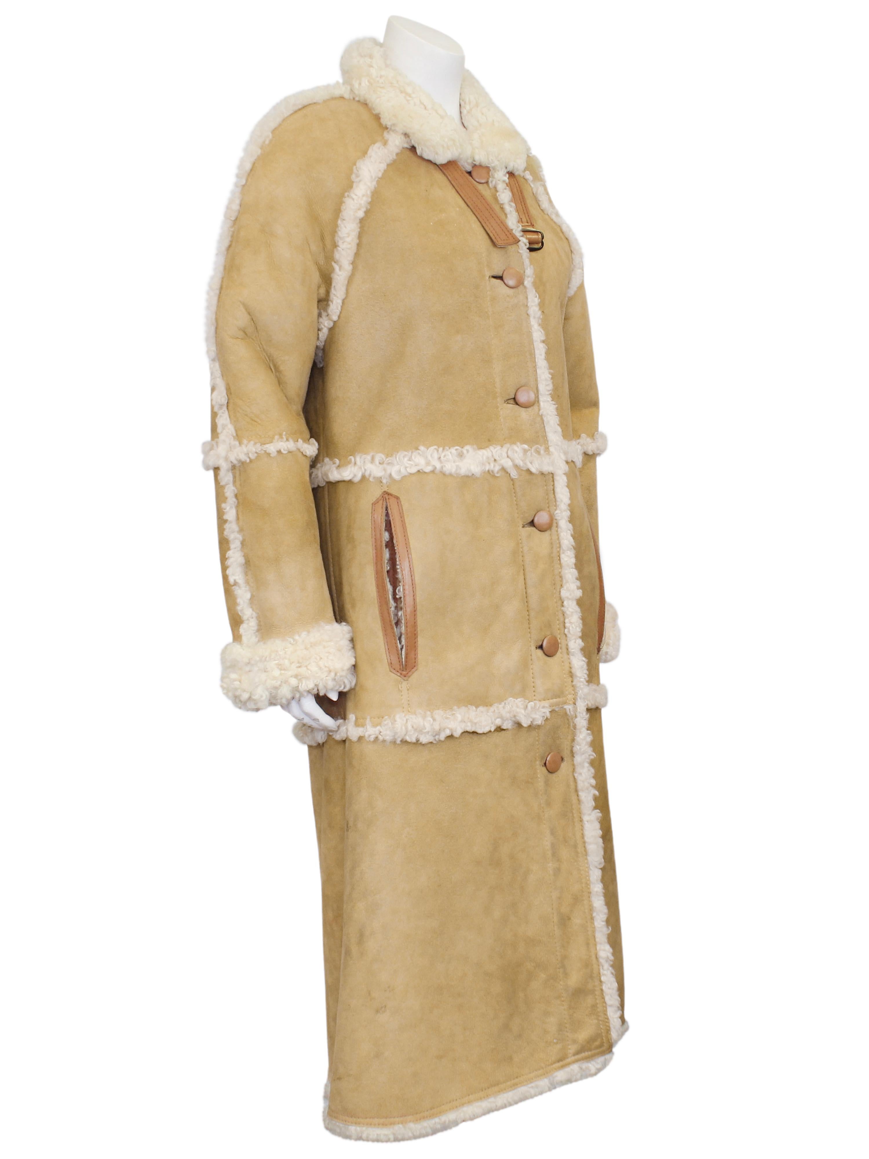 Made in France 1982 natural beige suede and curly sheepskin lined maxi coat. Tan leather trim on the slit side pockets, matching leather buttons and mini leather belt at the neck for additional protection from the cold. In good vintage condition