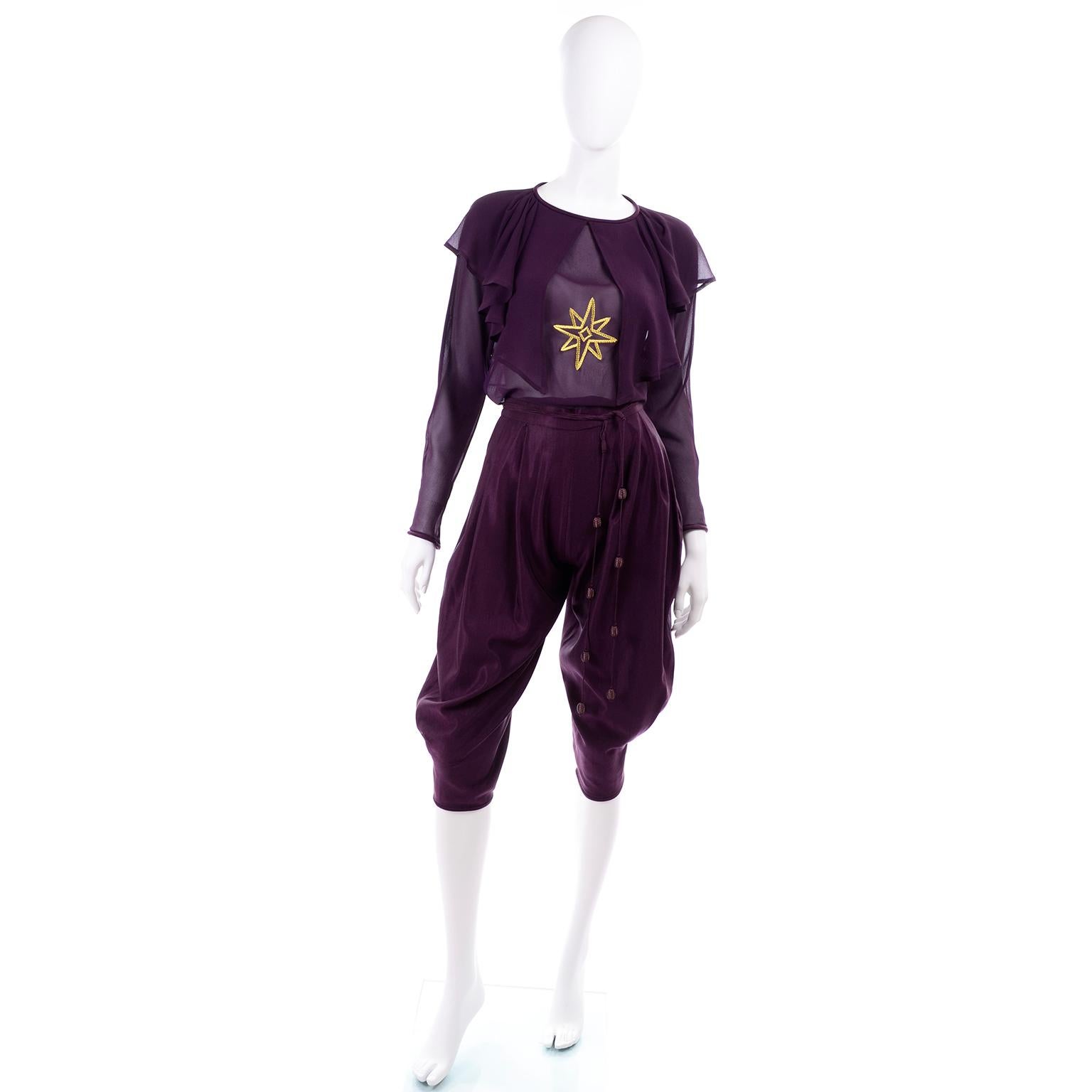 This is a rare vintage Gianni Versace 2 piece deep plum purple outfit from Fall/Winter 1981 that includes a pair of high waist knee length jodhpur style pants or knickers, and a beautiful silk chiffon blouse with a gold star embroidered on the
