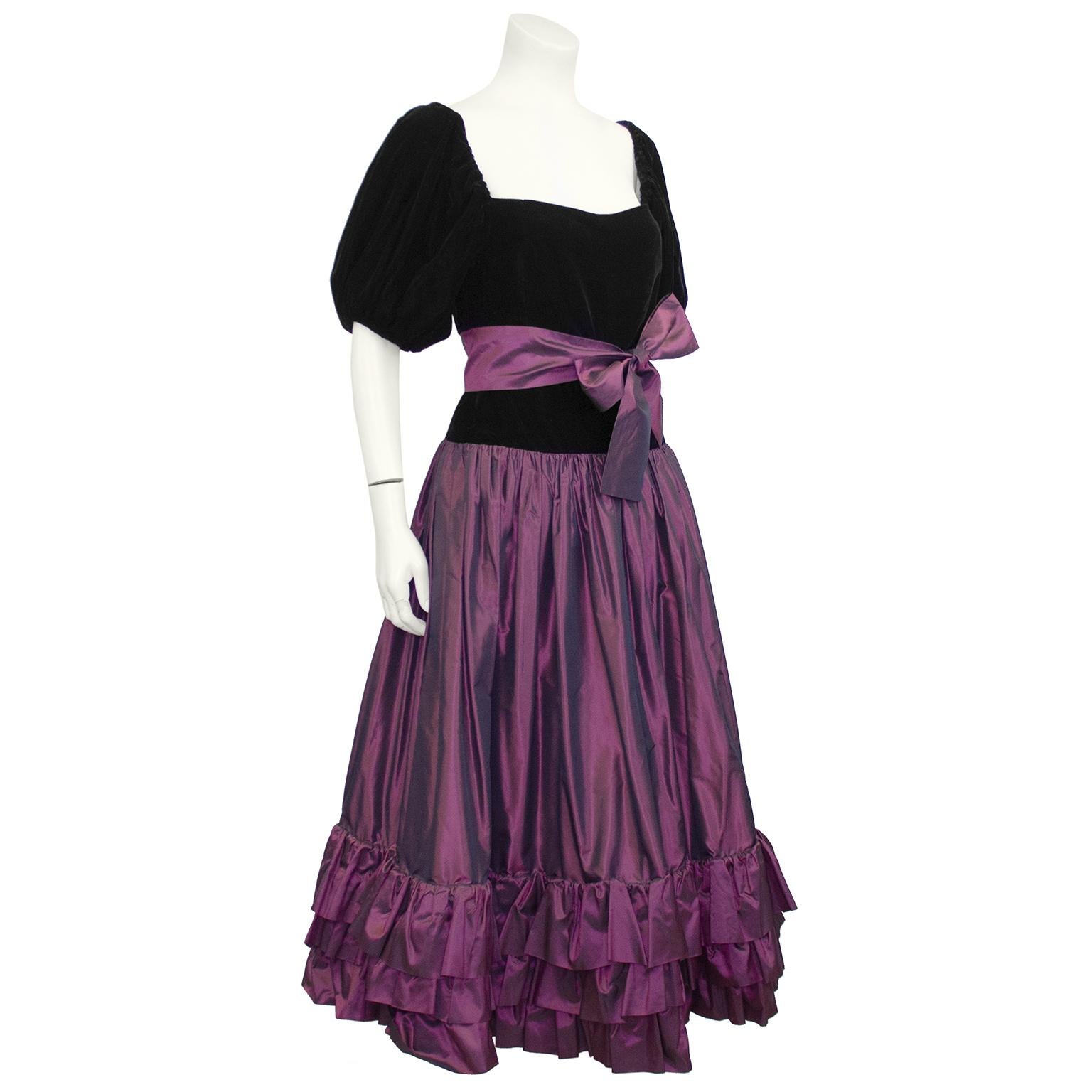 YSL Rive Gauche black velvet and purple taffeta skirt ensemble from 1981. The velvet top has short puff sleeves, a square neckline and is fitted through the body down to the hips. The purple taffeta skirt has a black velvet yoke at the top which