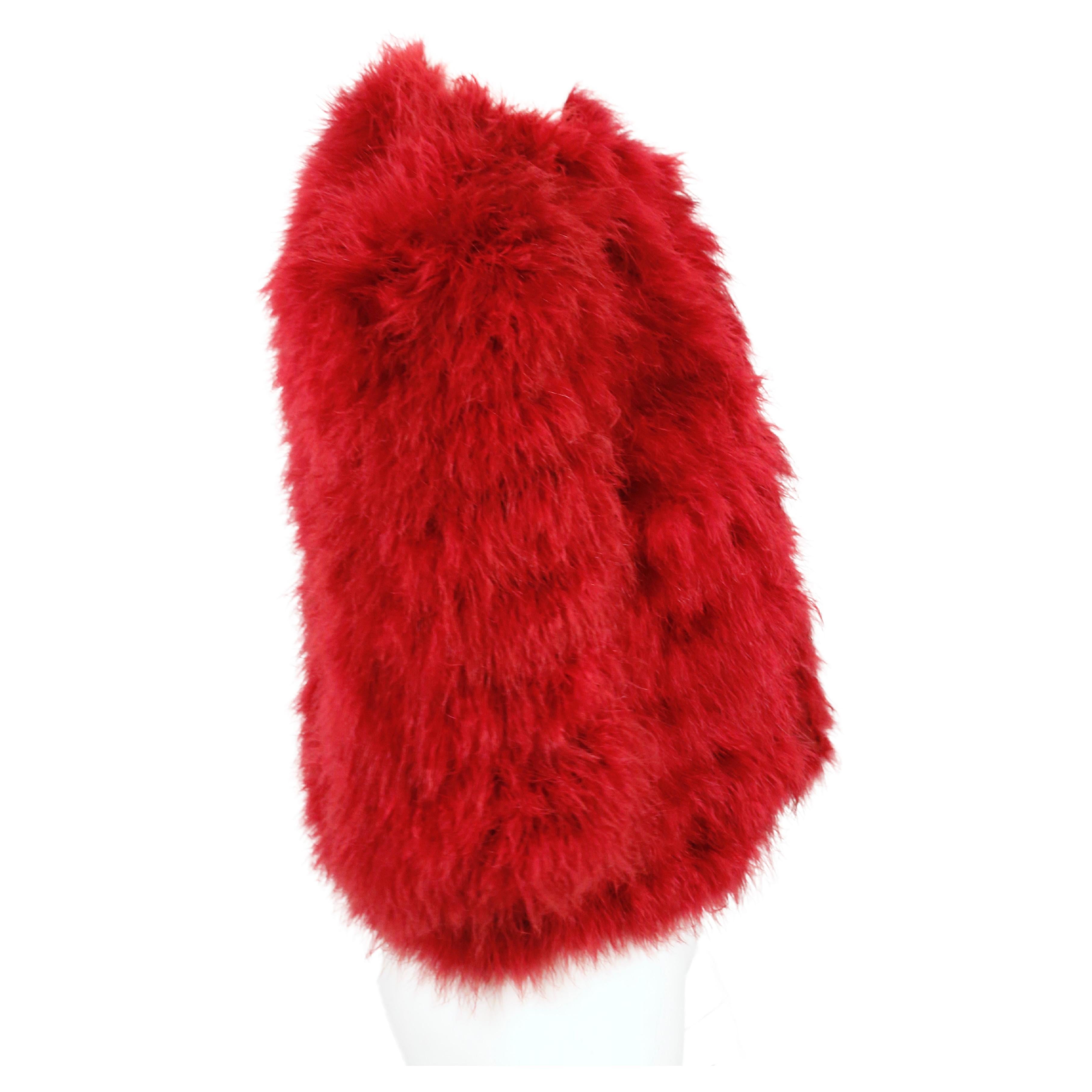 Fuchsiafarbene, mollige Jacke mit 3/4-Ärmeln aus Marabu-Federn, entworfen von Yves Saint Laurent im Herbst 1981, wie auf dem Laufsteg zu sehen. Dieses Stück ist auch Teil des Kostümarchivs des Met Museums und kann online eingesehen werden. Es ist