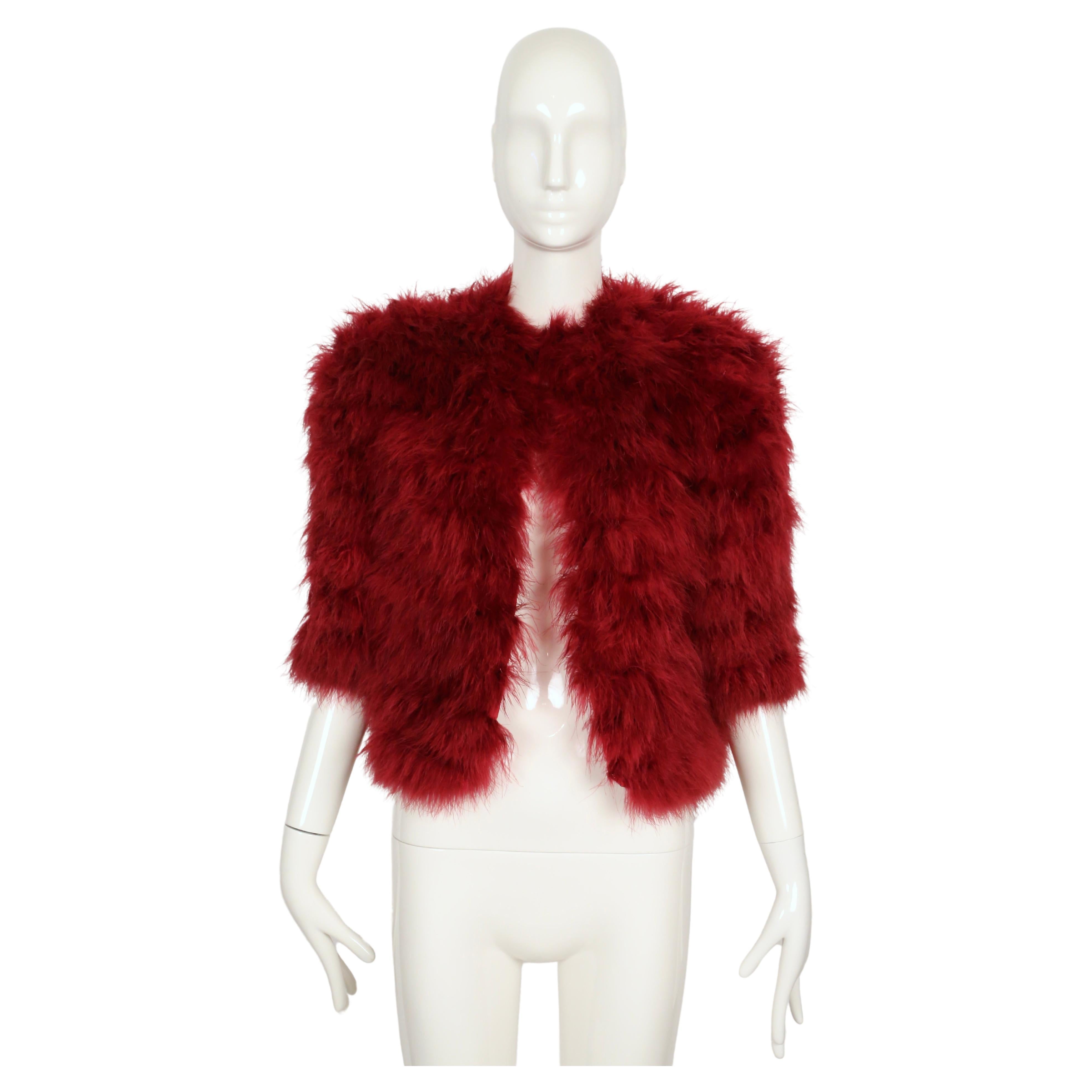 Giacca in piuma di marabù fucsia con maniche a 3/4 disegnata da Yves Saint Laurent e risalente all'autunno del 1981, così come è stata vista in passerella. Questo pezzo fa anche parte degli archivi dei costumi del Met Museum, visibili online. Non