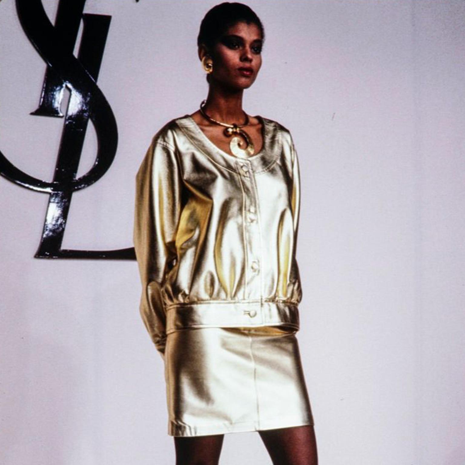 Superbe veste vintage d'Yves Saint Laurent en cuir argenté. Cette superbe veste YSL a des boutons centraux sur le devant, des manches surdimensionnées, un large col rond et elle est entièrement doublée. Nous avons documenté cette veste en or de la