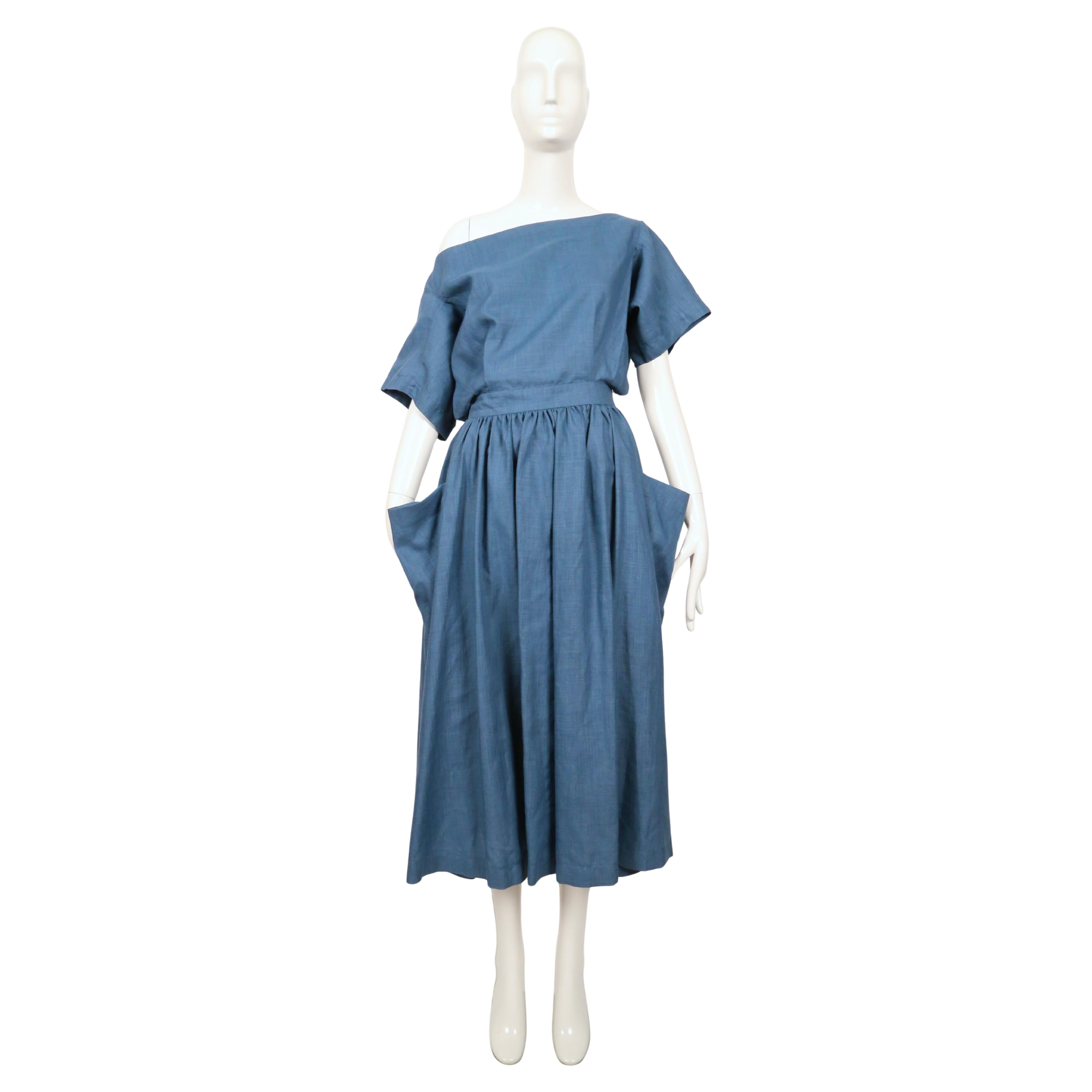 Rarísimo vestido de mezcla de lino de color turquesa vivo con espalda descubierta diseñado por Azzedine Alaia que data de su primera colección de verano, 1983. Este vestido tiene un escote sin hombros y un corpiño suelto que envuelve y llega a un
