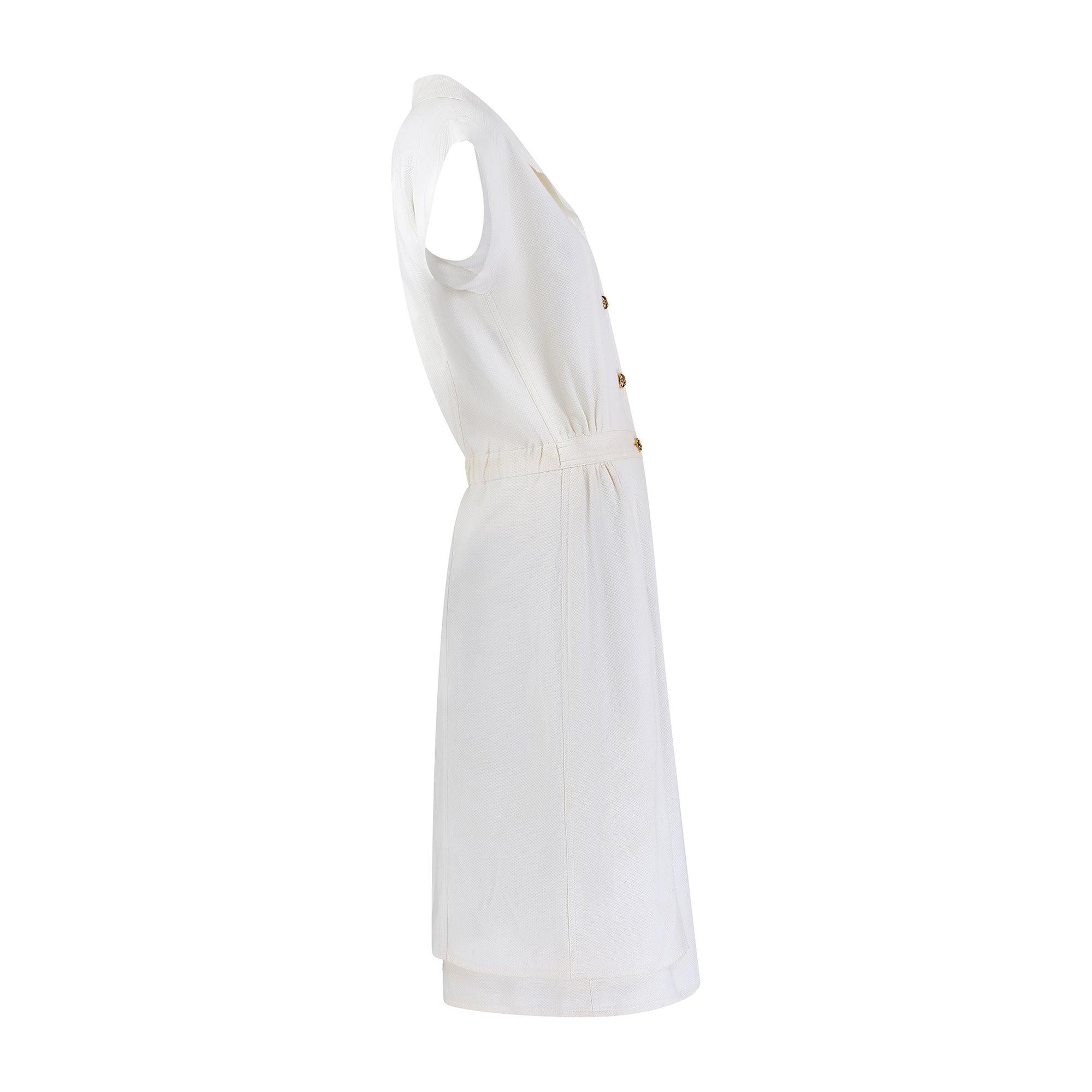 Chanel 1983 Spring / Summer collection white pique cotton midi dress. Pulling inspiration from the 1920s and 1930s and bringing the brand’s tailoring sophistication to a timeless shirt-dress silhouette, this piece is cut with a flattering nipped-in,