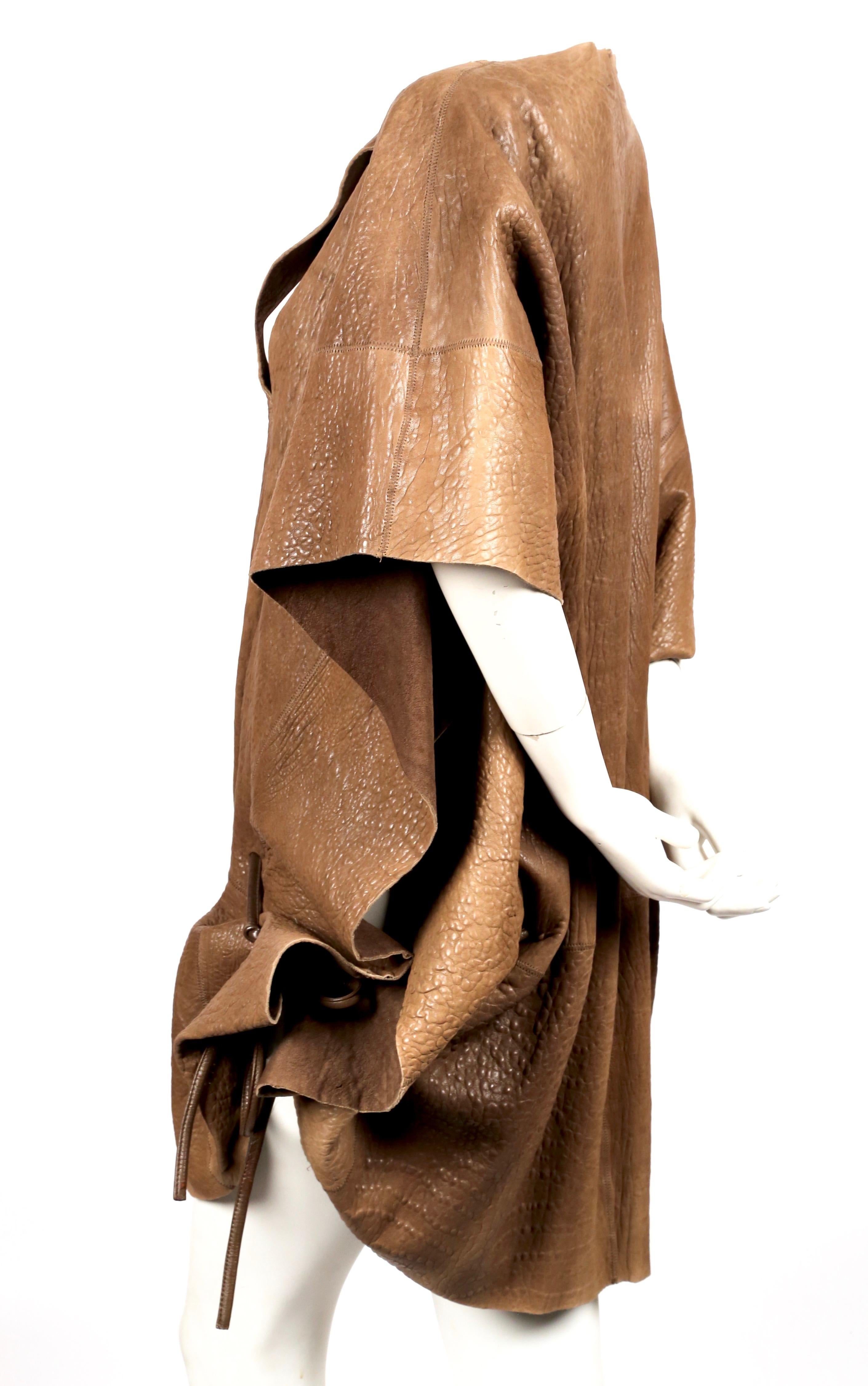 Very rare, tan, textured leather poncho coat designed by Issey Miyake exactly as seen on the fall 1983 runway. Labeled a size S. Approximate length 35