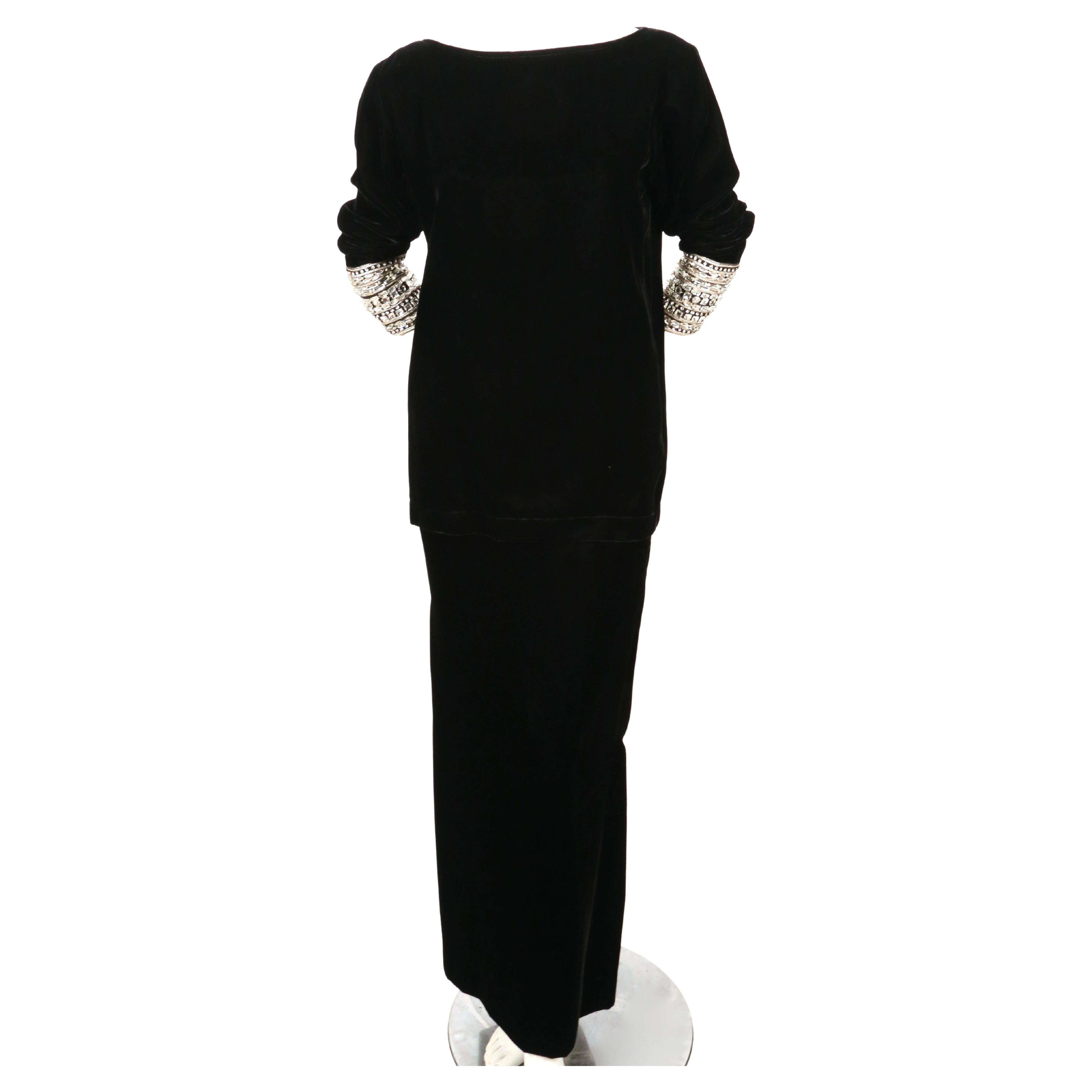 Jet-black, velvet tunic with crystal cuffs and matching maxi skirt designed by Yves Saint Laurent exactly as seen on the fall 1983 runway. Both pieces are labeled a size 36. Approximate measurements of top: bust 38-39