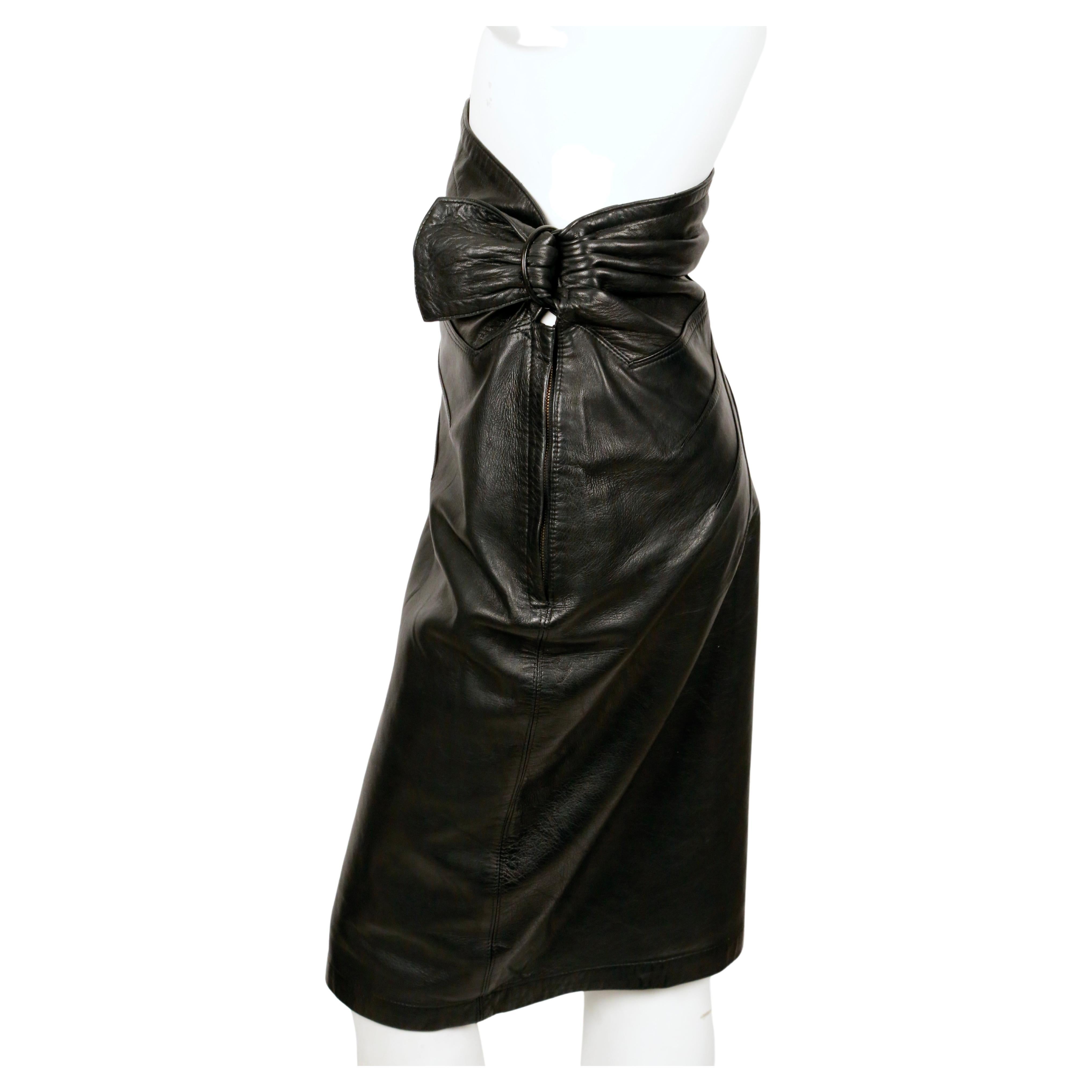 Black, butter-soft lambskin leather skirt with ruching, top-stitching and antiqued brass buckle detail from Azzedine Alaia dating to 1984. No size is labeled however this skirt best fits a U.S. size 6. Approximate measurements: waist 26-27