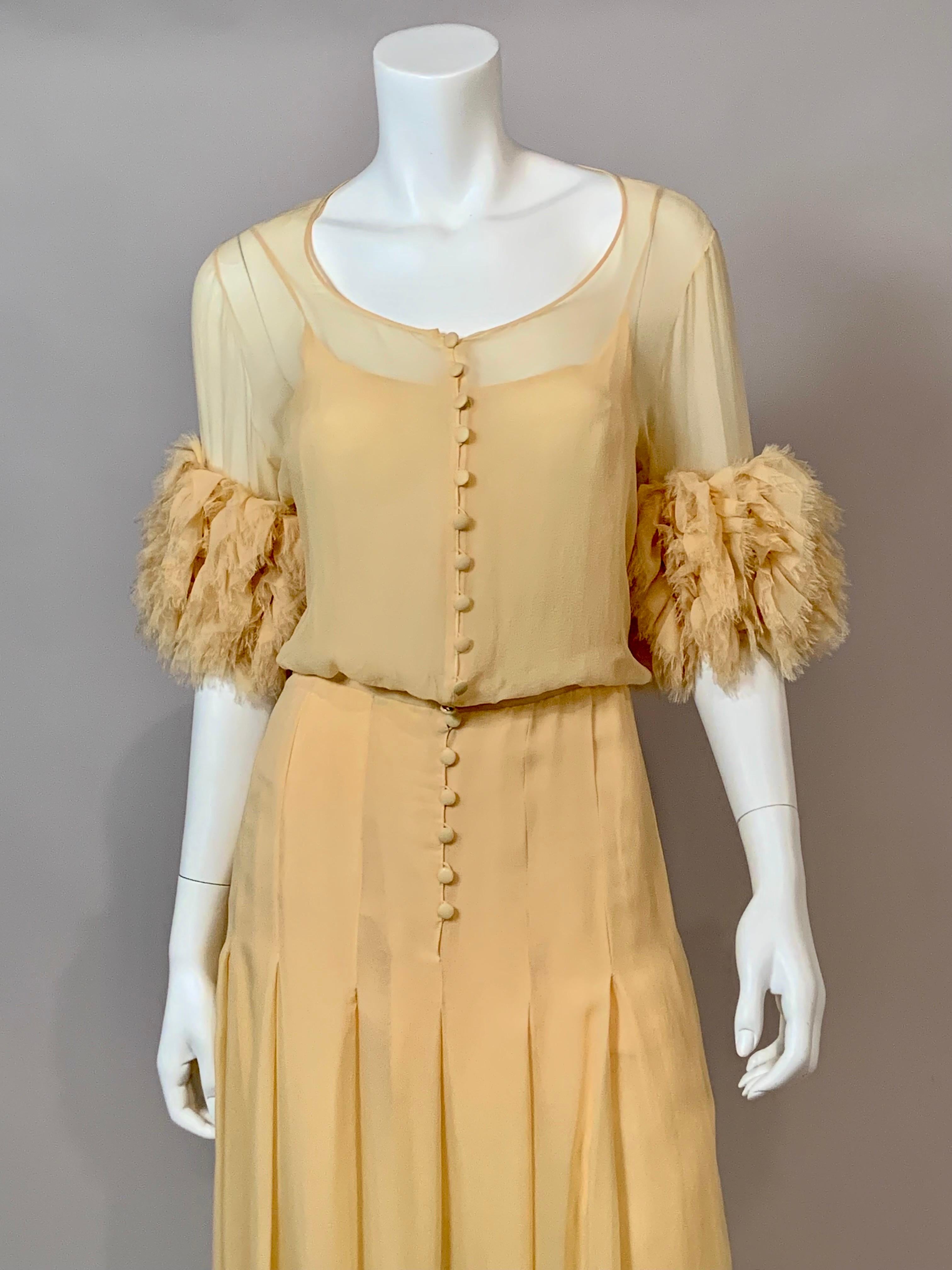 This elegant Chanel butter yellow silk chiffon evening gown was designed by Karl Lagerfeld for the Spring 1984 collection.  It has a round neckline, fabulous ruffled sleeves and covered buttons and loops at the center front. The skirt is two layers