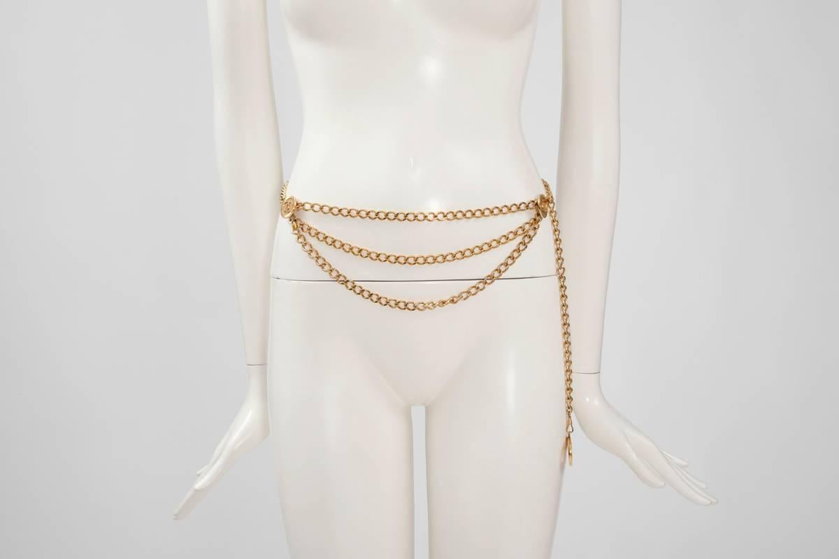 Timeless Chanel triple gold plated chain belt with iconic CC logo medallions. Two medallions (approx. 2.4 cm/0.9 inch each) are located at either side of the waist with three rows of hanging chains. The last one (approx. 3 cm/1.2 inch) is a