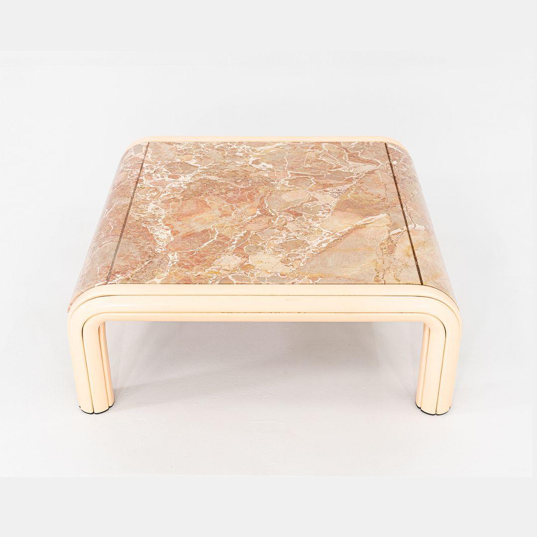 This is an Orsay Coffee Table, originally designed by Gae Aulenti for Knoll International in 1974. The Aulenti Collection was first manufactured in 1976 and stopped production in 1999. This table features a curved, cream lacquered aluminum frame,