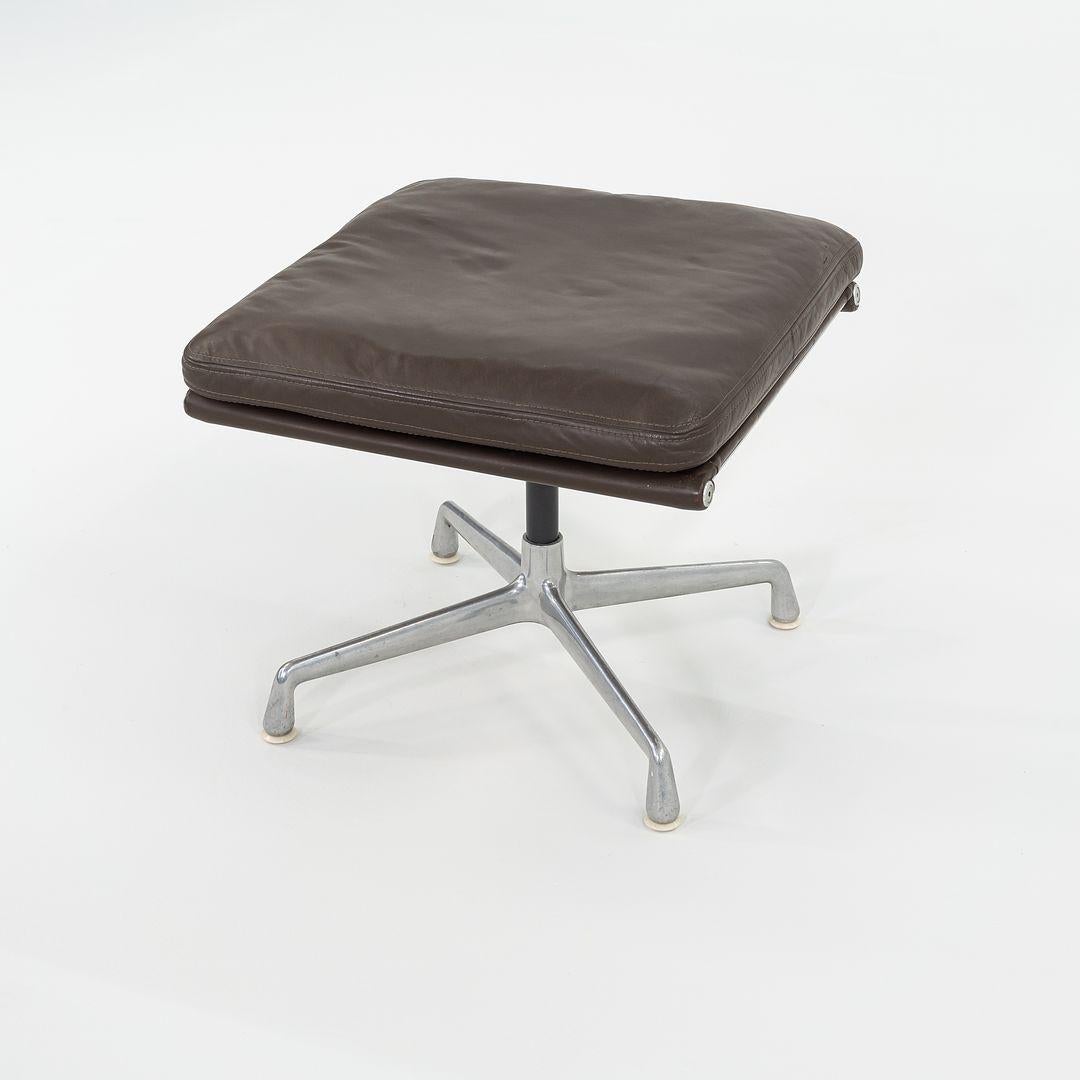 This is an Eames Soft Pad Ottoman, originally designed by Ray and Charles Eames in 1969. This particular example was produced by Herman Miller in the USA C. 1984. The design features a four-star cast aluminum base which is upholstered in a brown