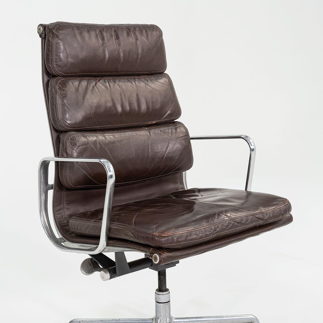 This is an Eames Aluminum Group Soft Pad Executive Chair, designed by Charles and Ray Eames for Herman Miller in 1968. This example dates to 1984. The design features a cast aluminum frame with an adjustable five-star base, and has dark brown