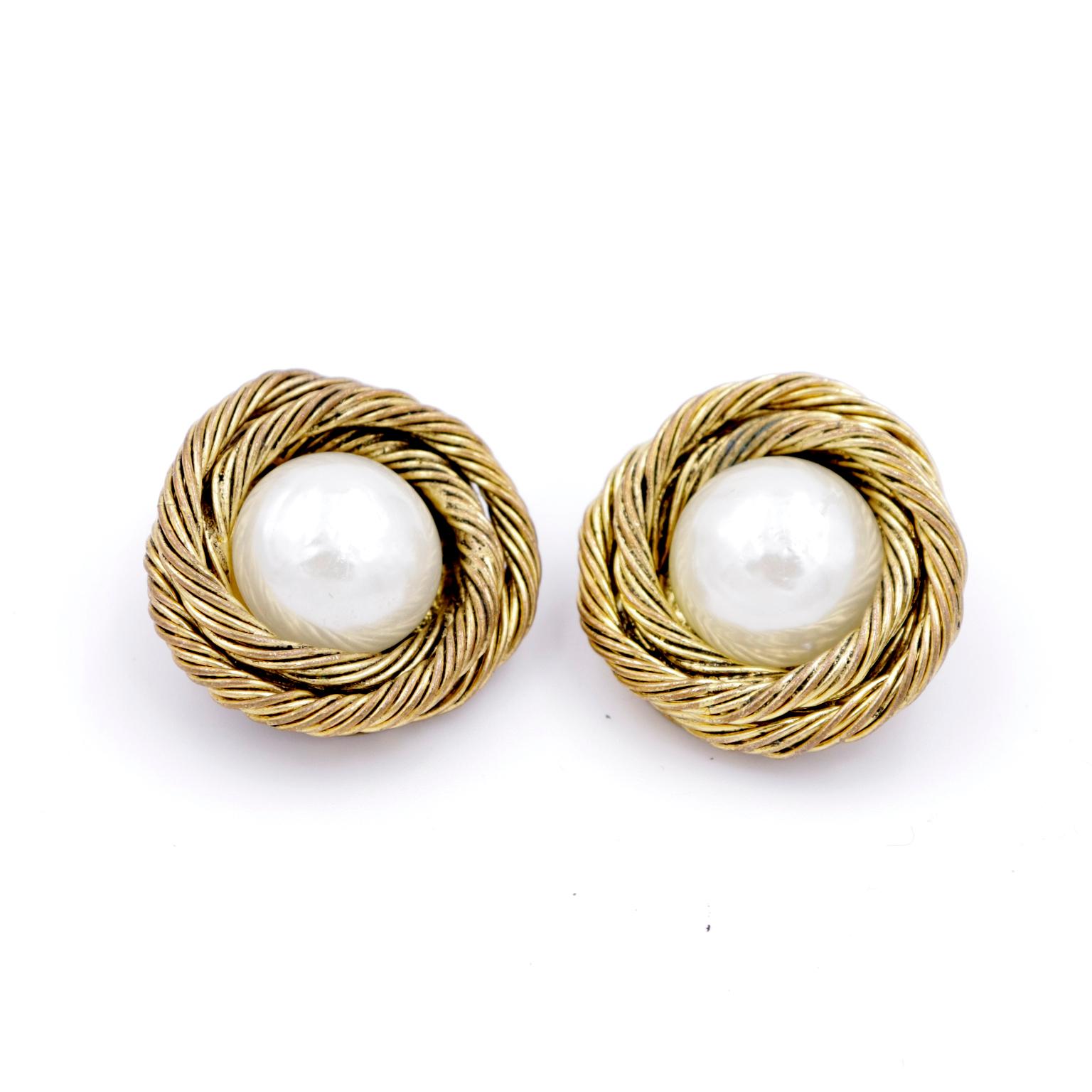 These vintage 1985 Chanel Twisted rope gold gilded clip earrings feature a center simulated pearl cabochon. The earrings have the 1985 Chanel mark on the back and come with their original box
WIDTH: 1 1/8