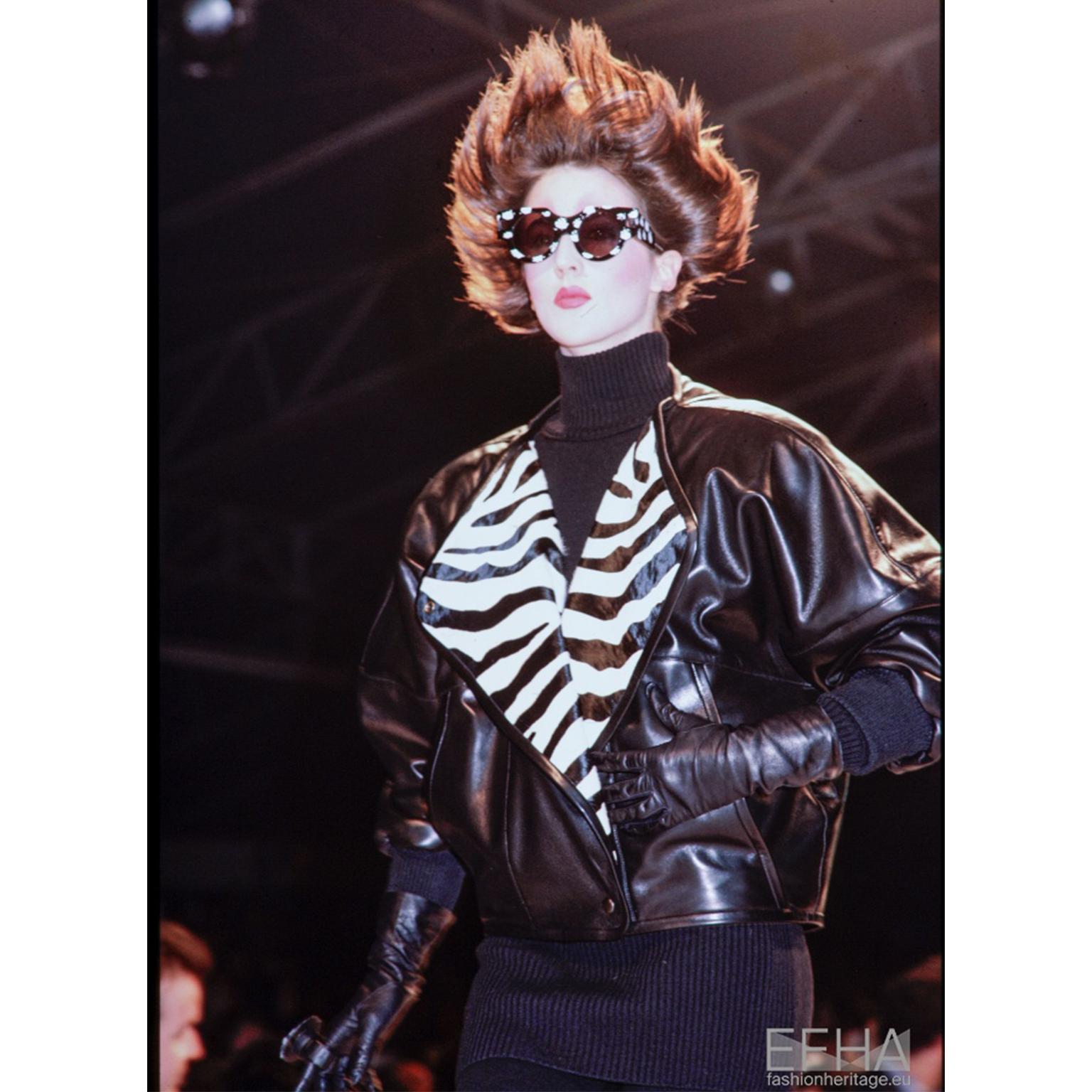 This vintage Claude Montana pour Ideal Cuir black leather jacket was featured on the F/W 1985 runway. Claude Montana designed this jacket with both zebra and giraffe print lapels. This oversized, drop shoulder jacket is in a luxe lamb leather with