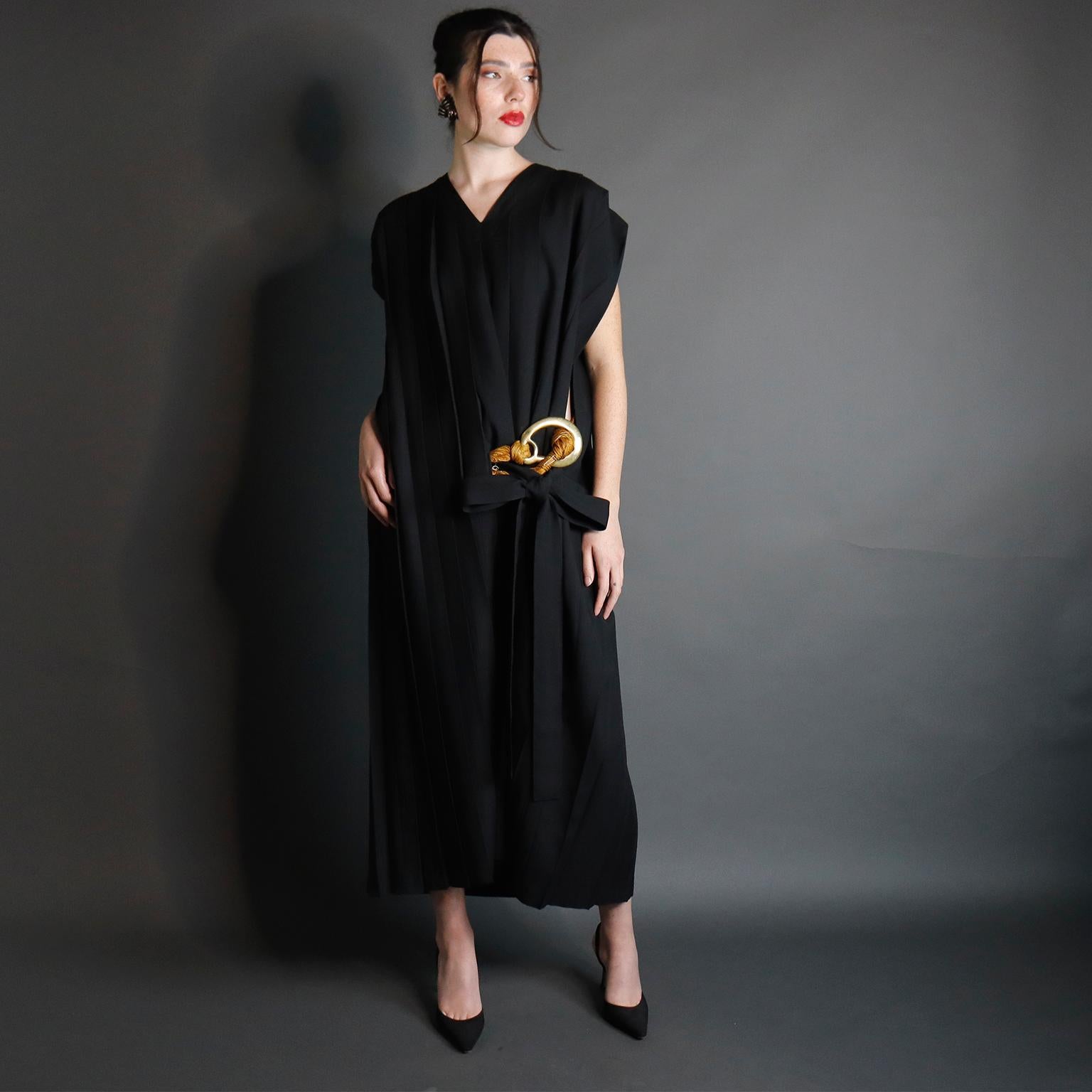 This rare vintage Comme des Garcons dress is from the 1985 runway collection. This avant garde black wool challis dress is vertically pleated throughout with 1'' to 2.5'' pleats. The dress has a straight, rectangular fit with rounded shoulders with