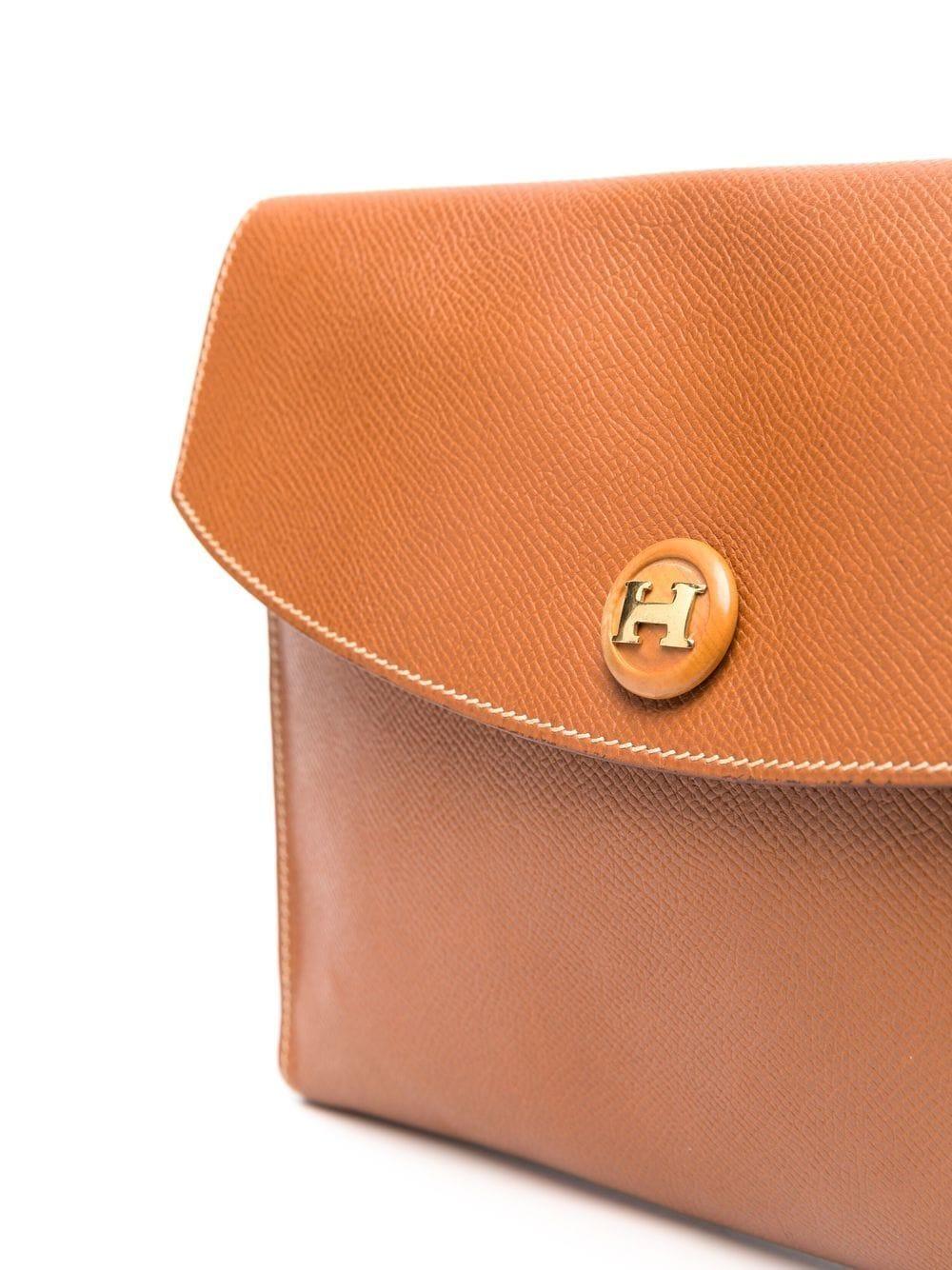 Hermes camel Courchevel leather Rio clutch featuring an envelope design, a logo-embossed buttons, foldover top with press-stud fastening, inside stamp Hermes Paris.
Circa 1985
In good vintage condition. Made in France.
We guarantee you will receive