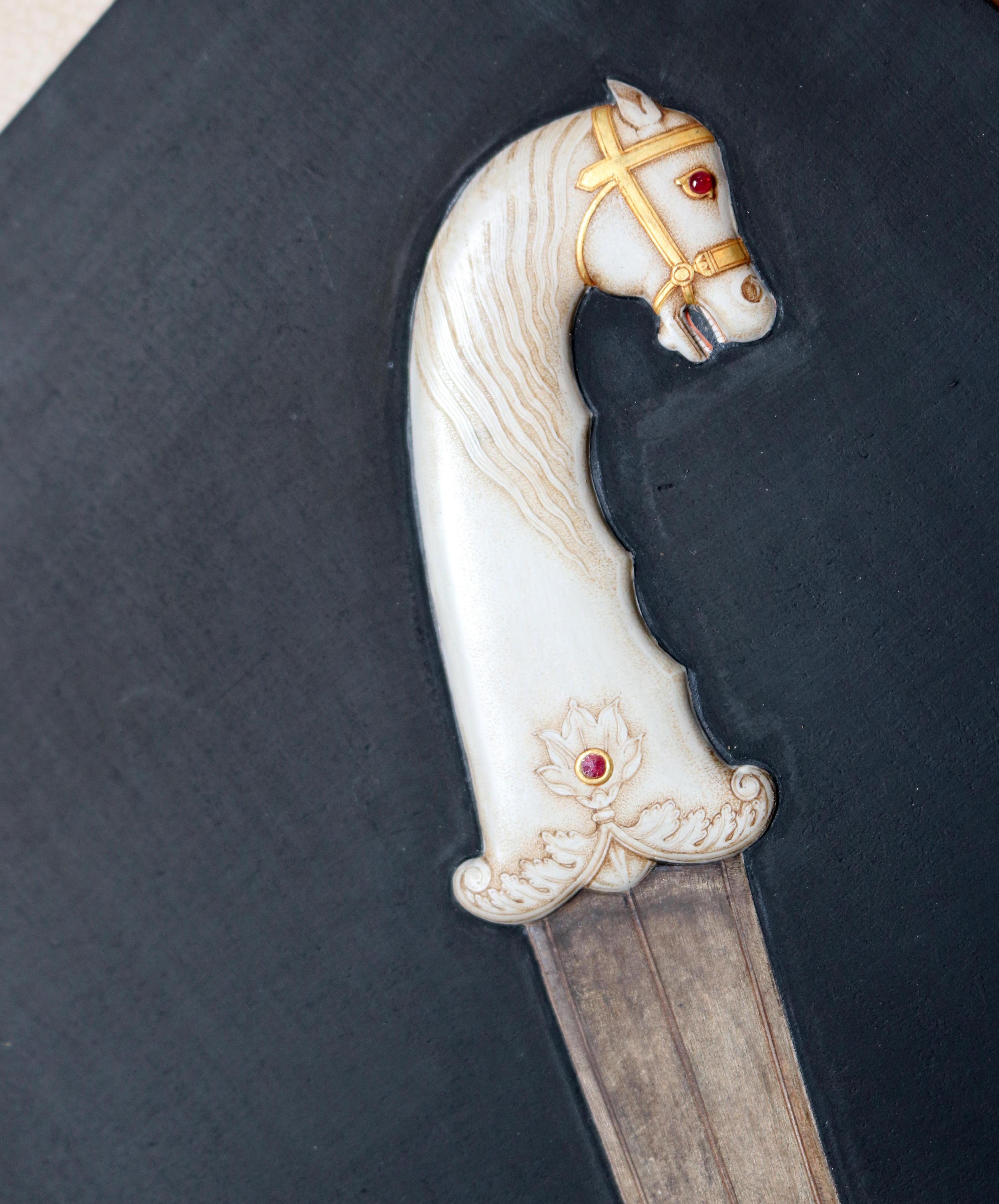 1985 hyperrealist relief painting of a hand drawn horse shaped dagger using vivid colors, including gold gilding. Signed Ramesh Sharma.