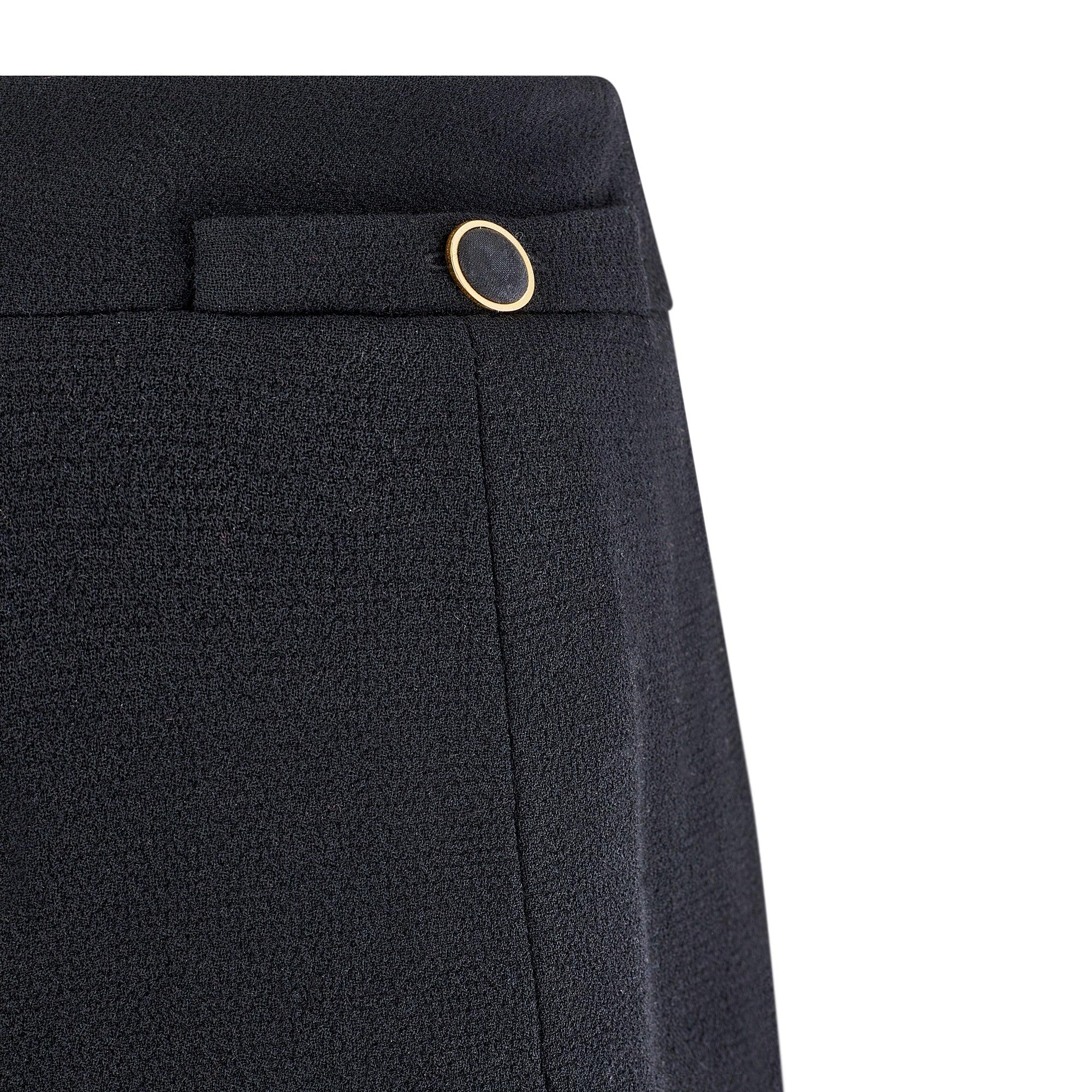 This elegant black runway documented skirt is an early design by Karl Lagerfeld for the Chanel 1985 spring collection. Bringing the brand’s timeless sophistication to a pleated mini-skirt silhouette, this wool and silk piece has a tiered