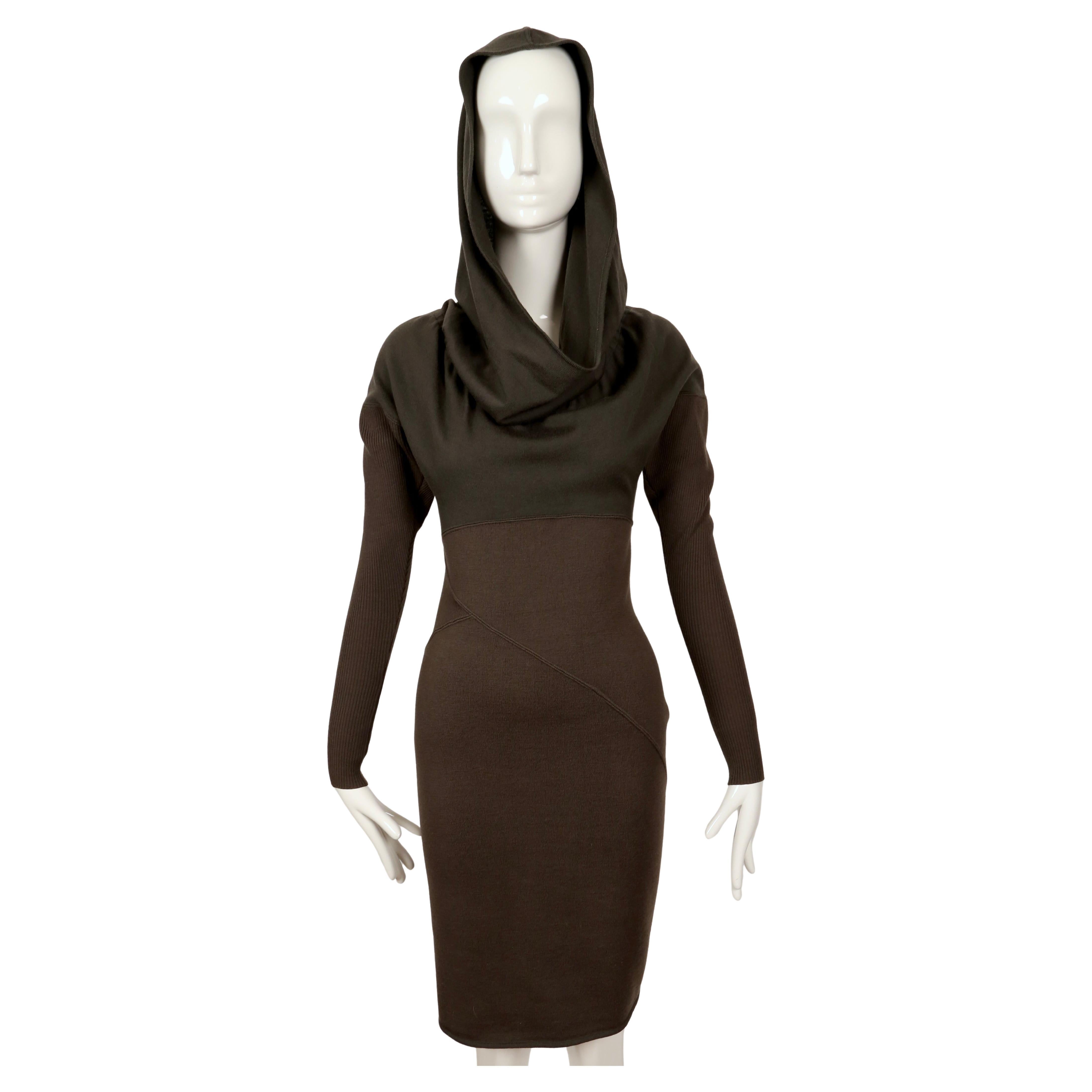 Iconic, green-brown wool dress with unique seaming and large hood designed by Azzedine Alaia dating to fall of 1986 as seen on the runway.  'Hood' can be draped for a more conventional look. Arms are made of a contrasting ribbed wool and are very