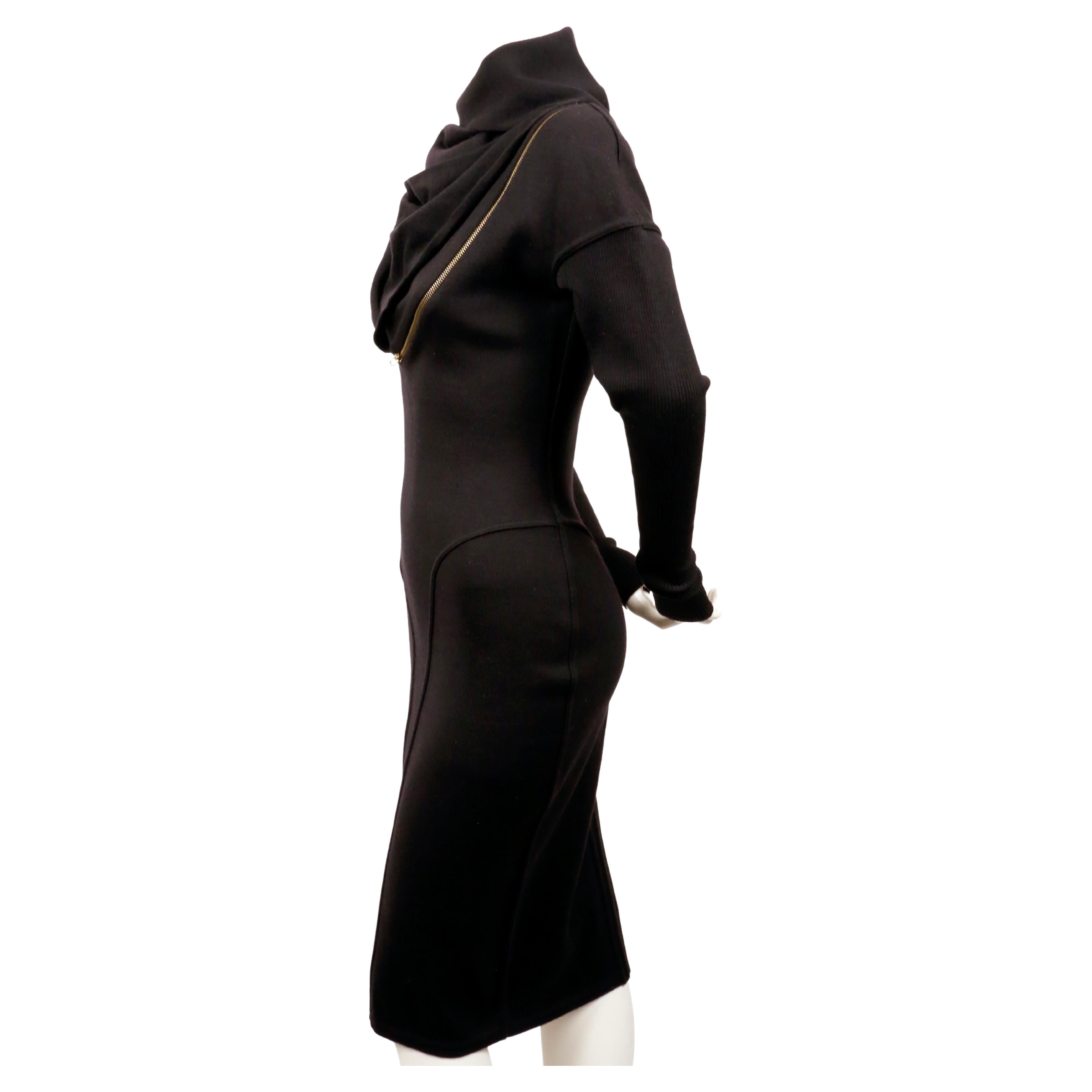 Iconic, jet-black wool, seamed, zipper dress with large hood designed by Azzedine Alaia dating to fall of 1986 as seen on the runway. Well documented piece. Very flattering seams with spiral zipper that cleverly follows the contours of dress seams.