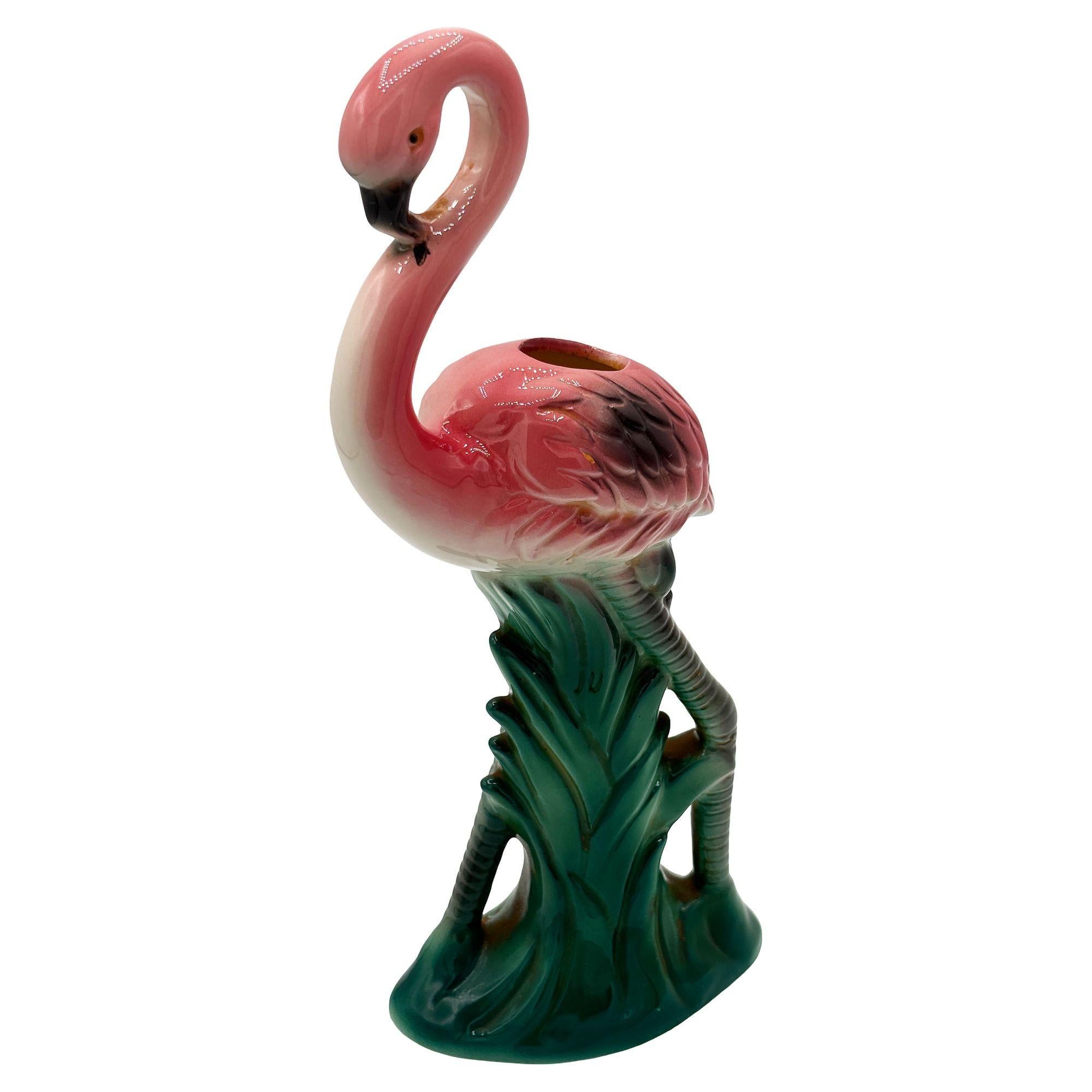 Vaso da tavolo del 1986 in ceramica rosa e verde con fenicottero di Sarsaprilla Studio. Il vaso presenta un fenicottero rosa splendidamente dettagliato che si erge su un campo erboso verde e rigoglioso. La finitura lucida mette in risalto i ricchi